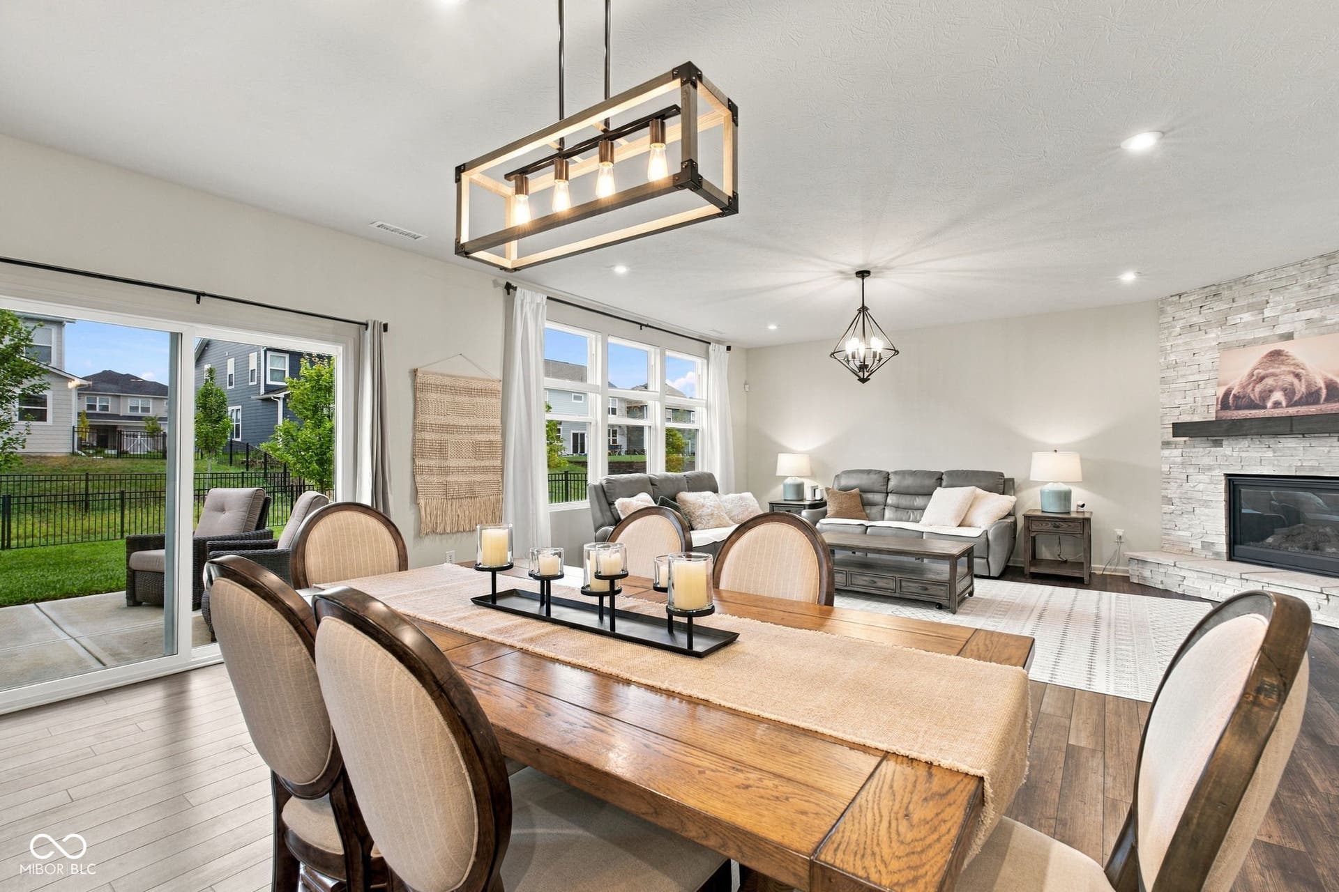 Dining and Great Room - Open-concept living area featuring a stone accent fireplace, wood-finish flooring, and recessed lighting