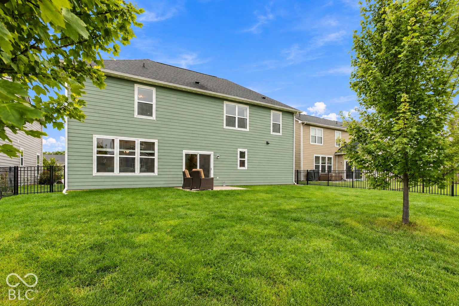 Rear Exterior with trees, fenced in backyard and patio