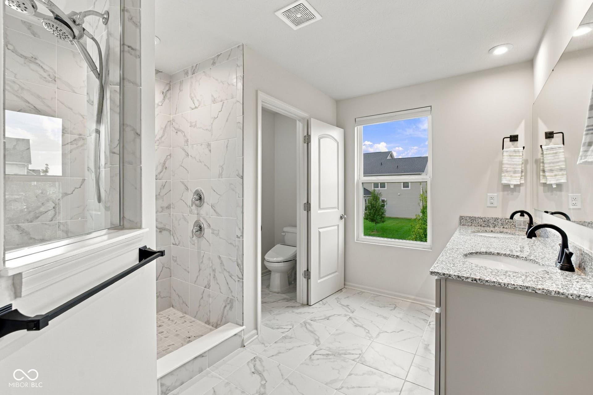 Walk-in shower with tiled walls and glass enclosure