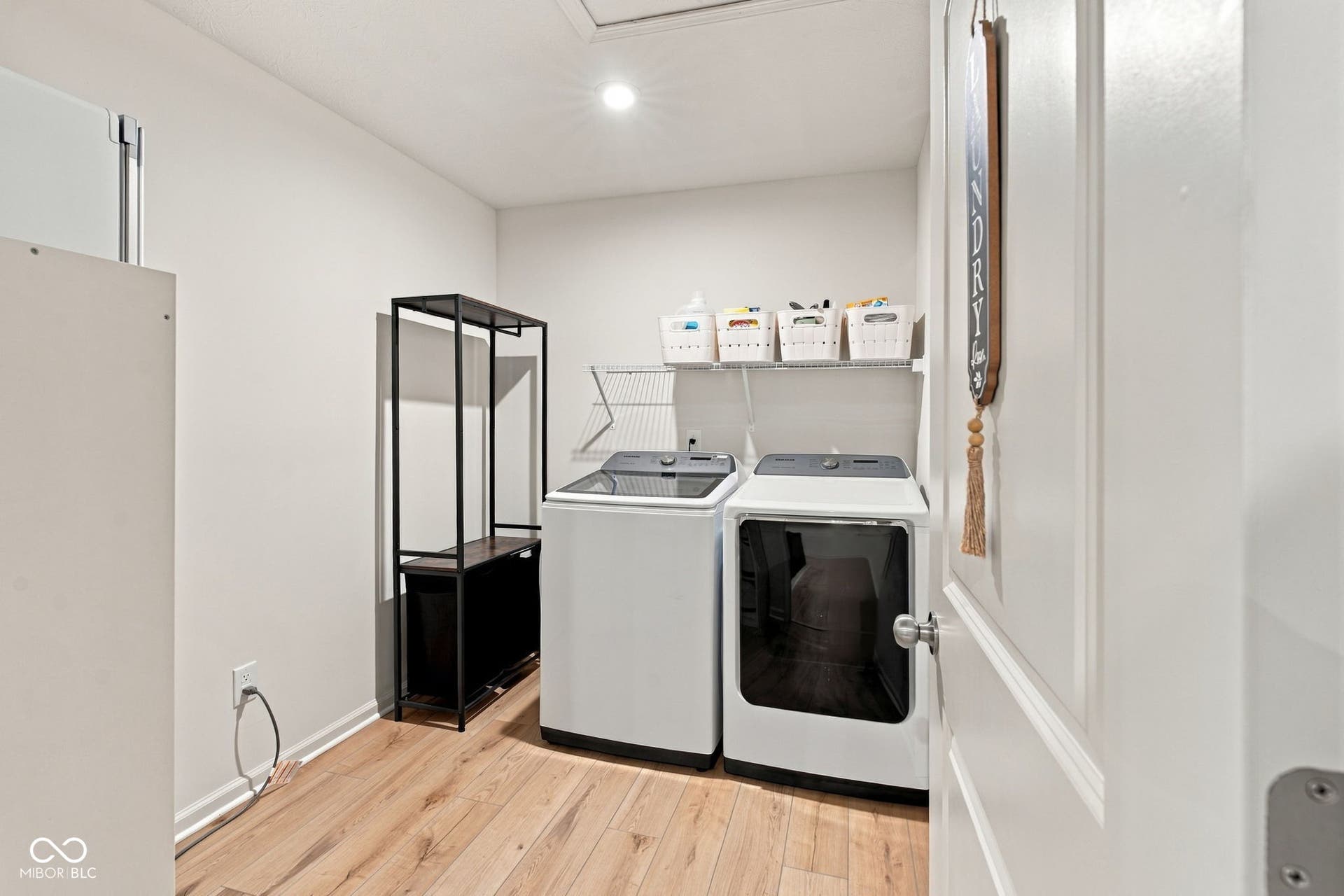 Utility space with wood-finish flooring, recessed lighting, and wall-mounted shelving