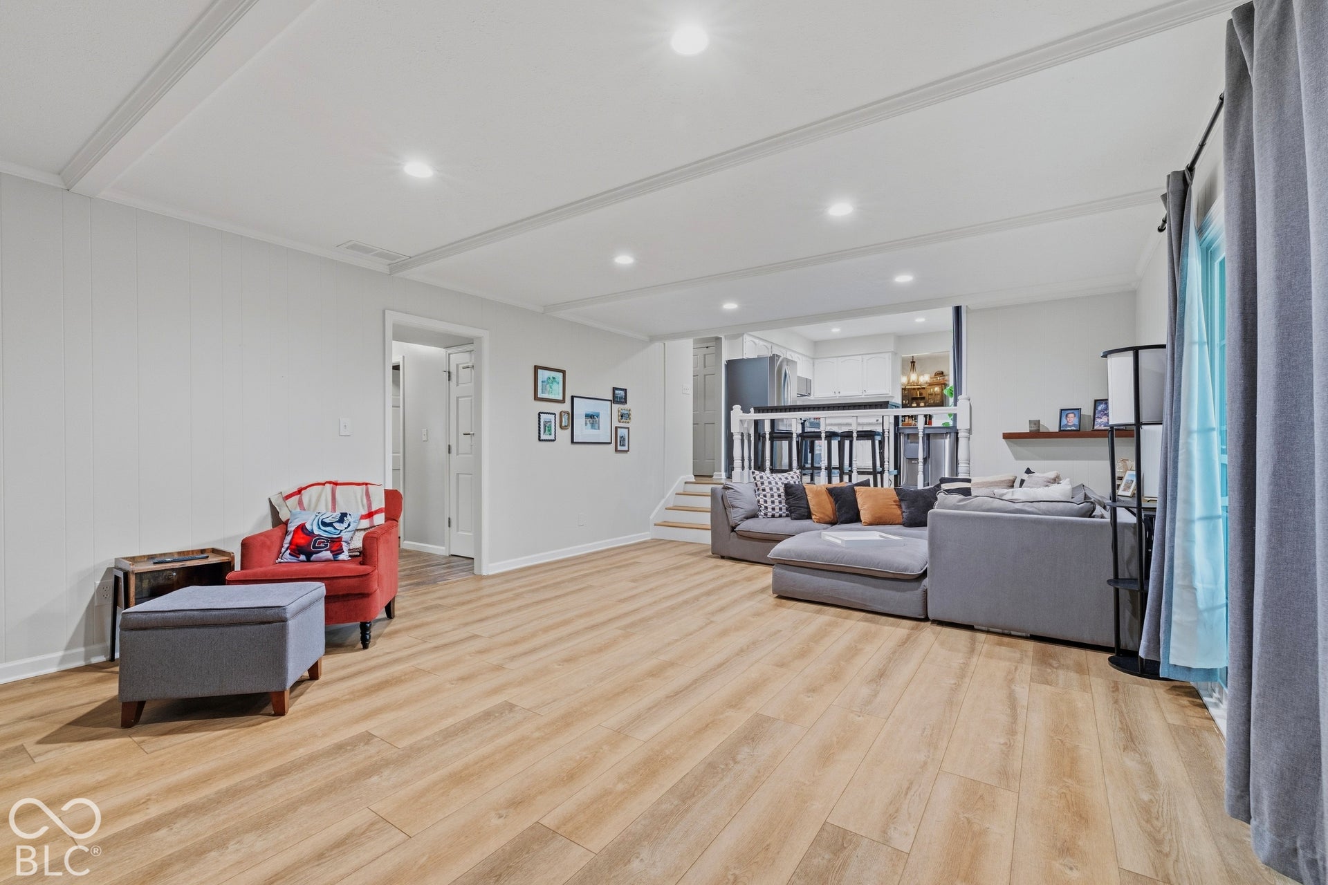 Wood-finish flooring throughout, recessed lighting, and a paneled accent wall