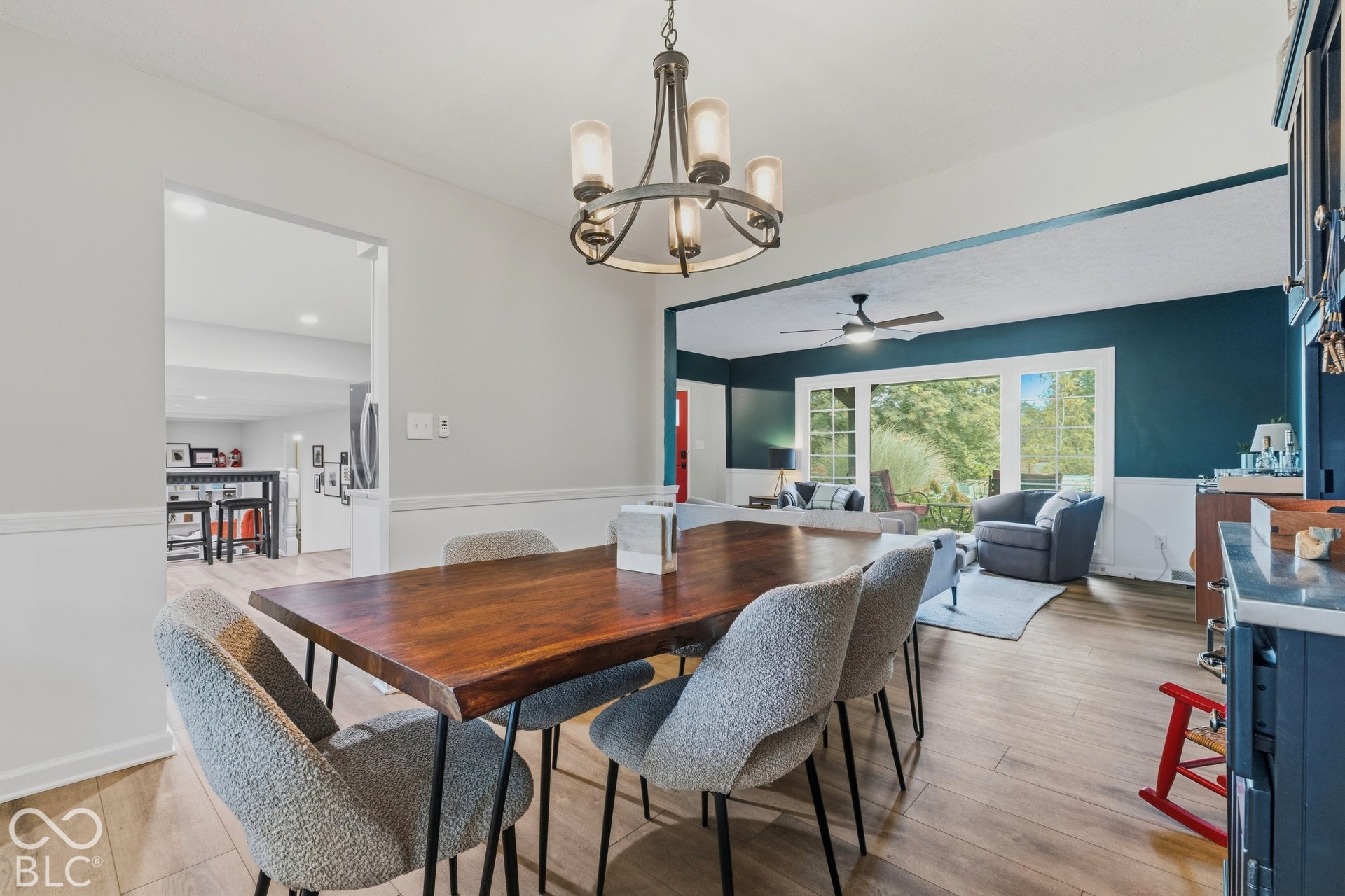 Dining area featuring a wood-finish flooring, a contemporary chandelier, and an expansive doorway