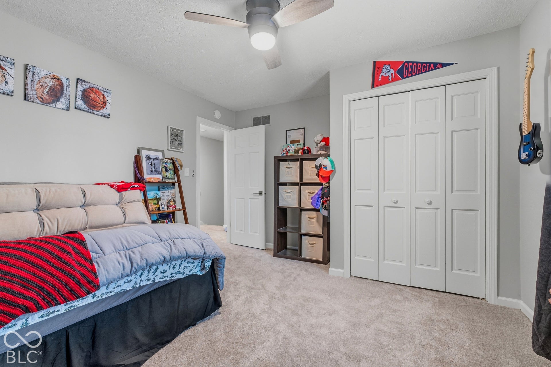 Neutral wall paint, ceiling fan with integrated lighting, carpet flooring, and bi-fold closet doors