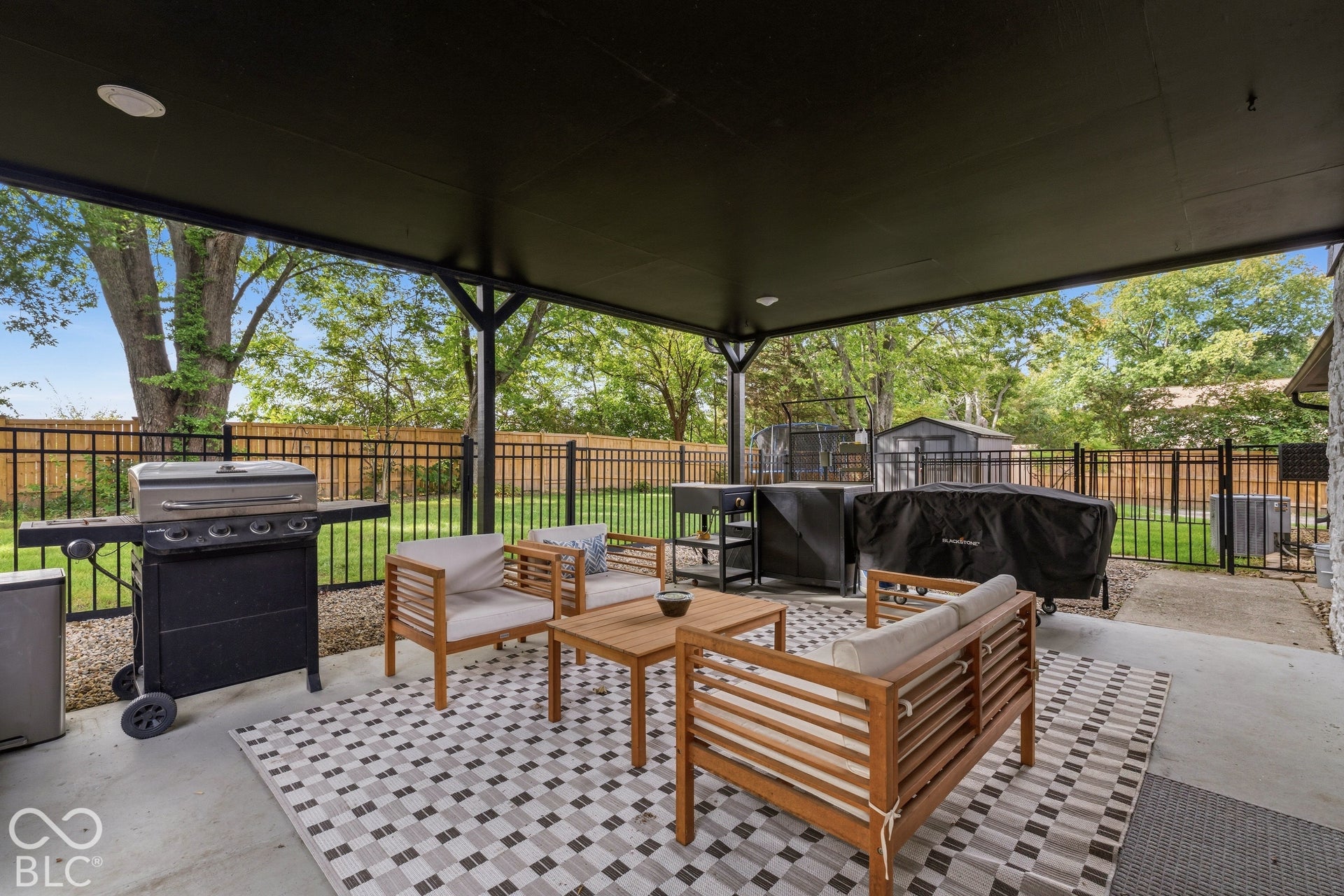 Covered patio with recessed lighting, concrete flooring, and black metal fencing