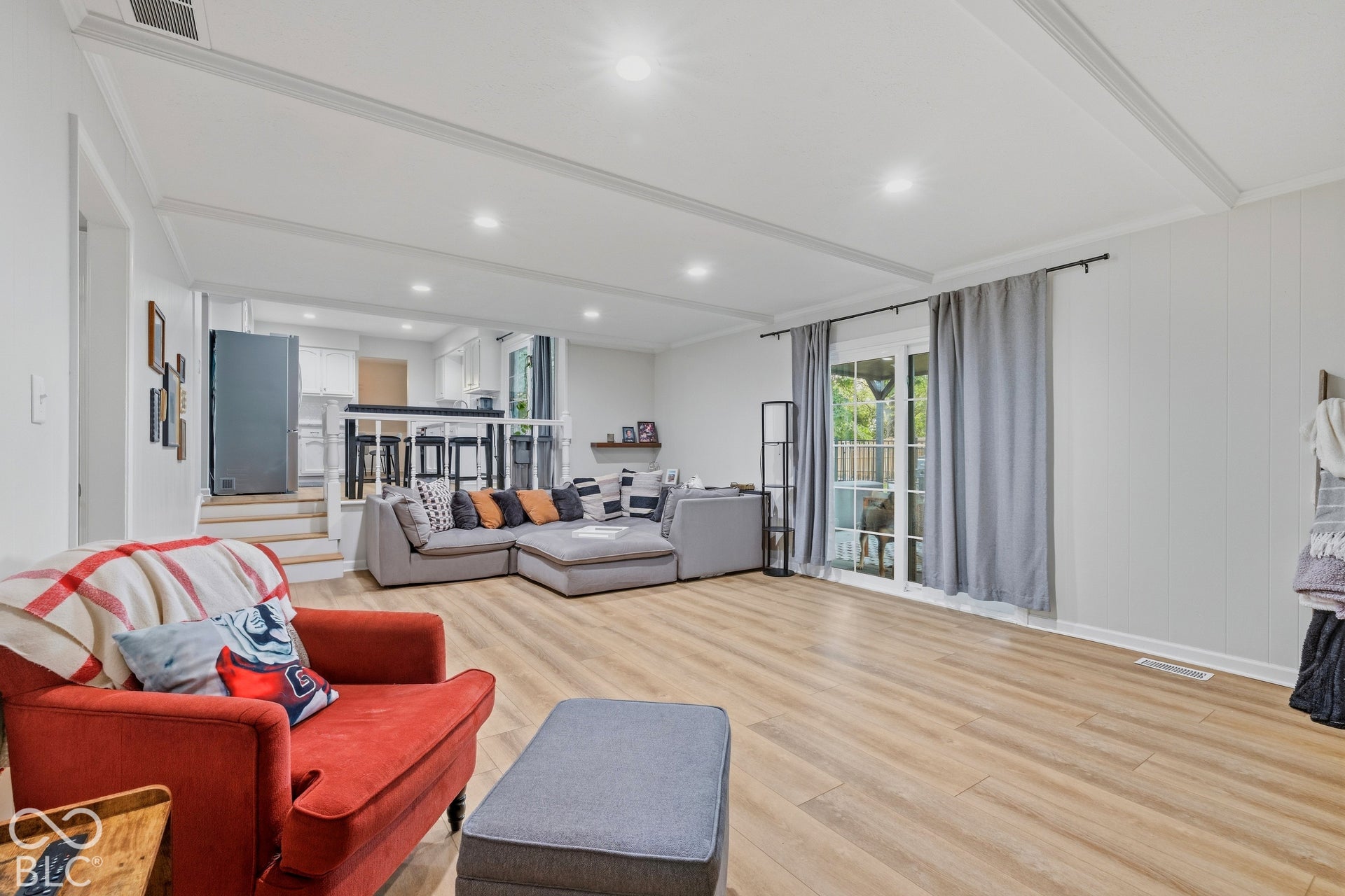 Wood-finish flooring, recessed lighting, white paneling, and a sliding glass door