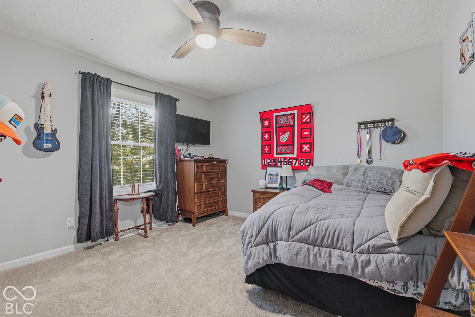 Carpeted flooring, window with blinds, ceiling fan with integrated lighting, and neutral wall tones