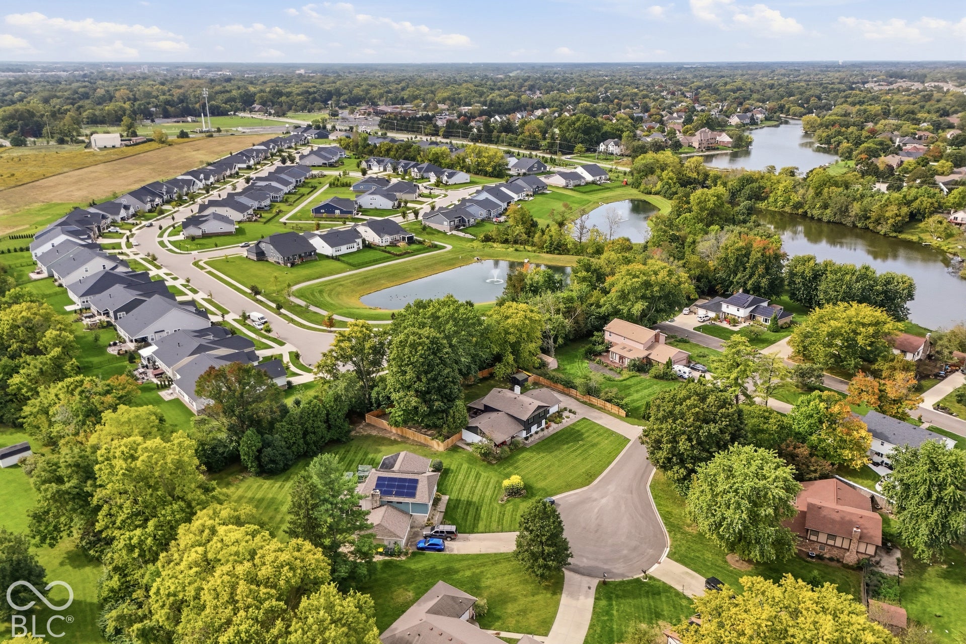 Residential development with varying architectural styles, established landscaping, and multiple bodies of water