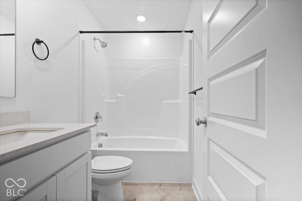 White vanity with a light-toned countertop, integrated sink, and chrome faucet