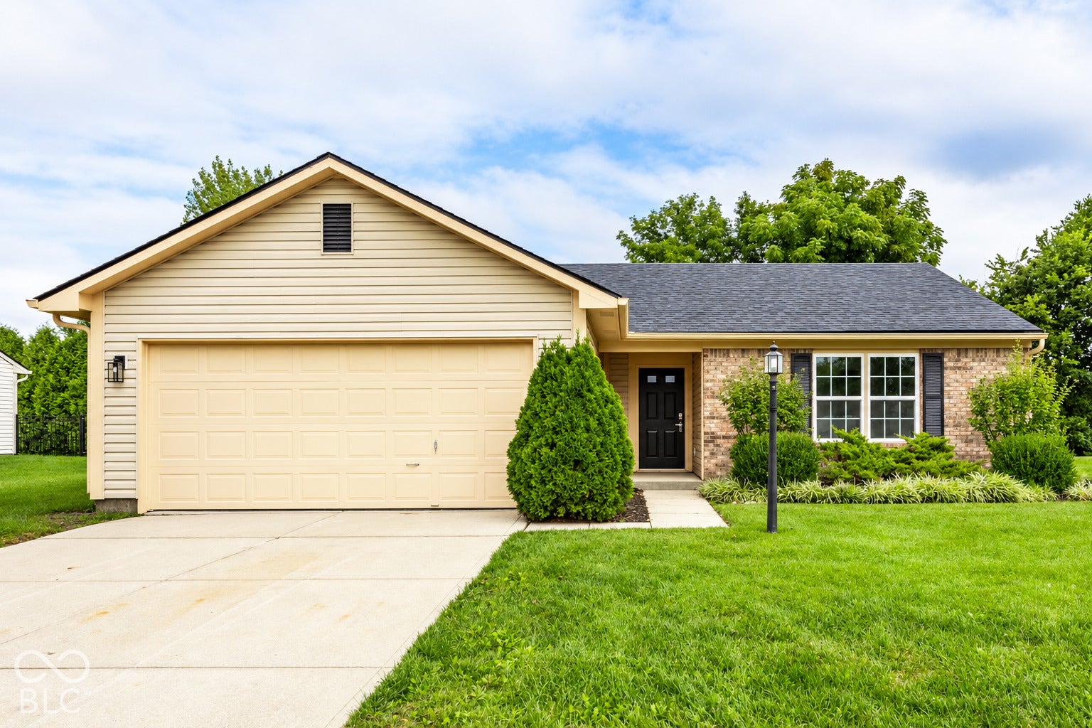 Brick and siding exterior with a dark shingle roof, attached garage, and concrete driveway