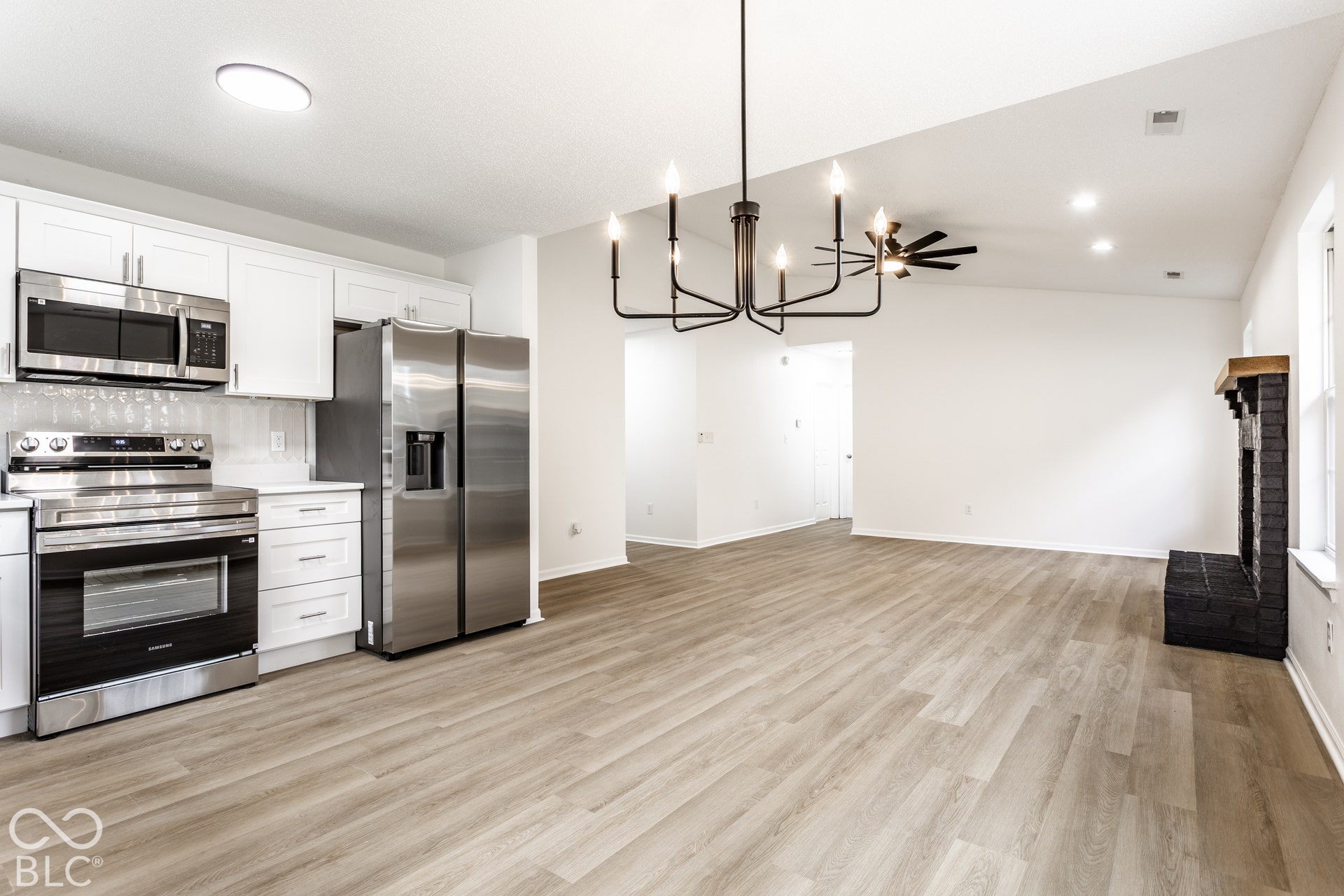 Kitchen featuring stainless steel appliances, white cabinetry, and a tile backsplash