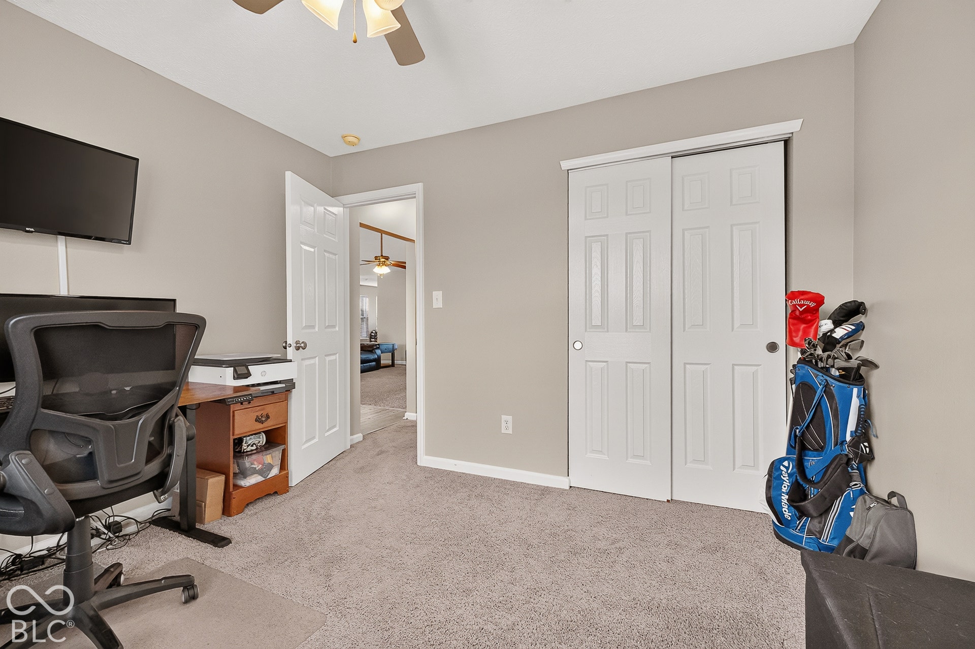 Neutral tone wall paint, carpeted flooring, and a ceiling fan with integrated lighting