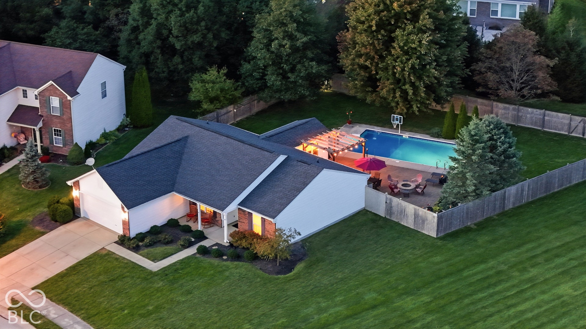 Expansive backyard featuring a fenced-in swimming pool, paved patio, and pergola