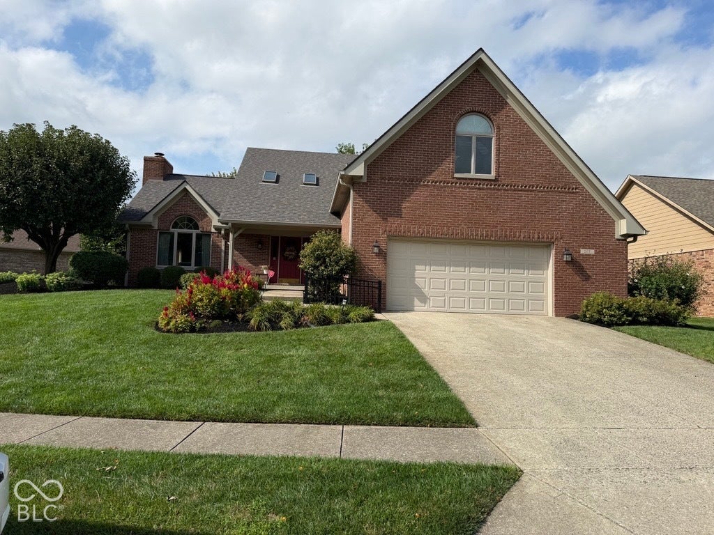 Brick exterior with an attached garage, arched window, and gabled rooflines