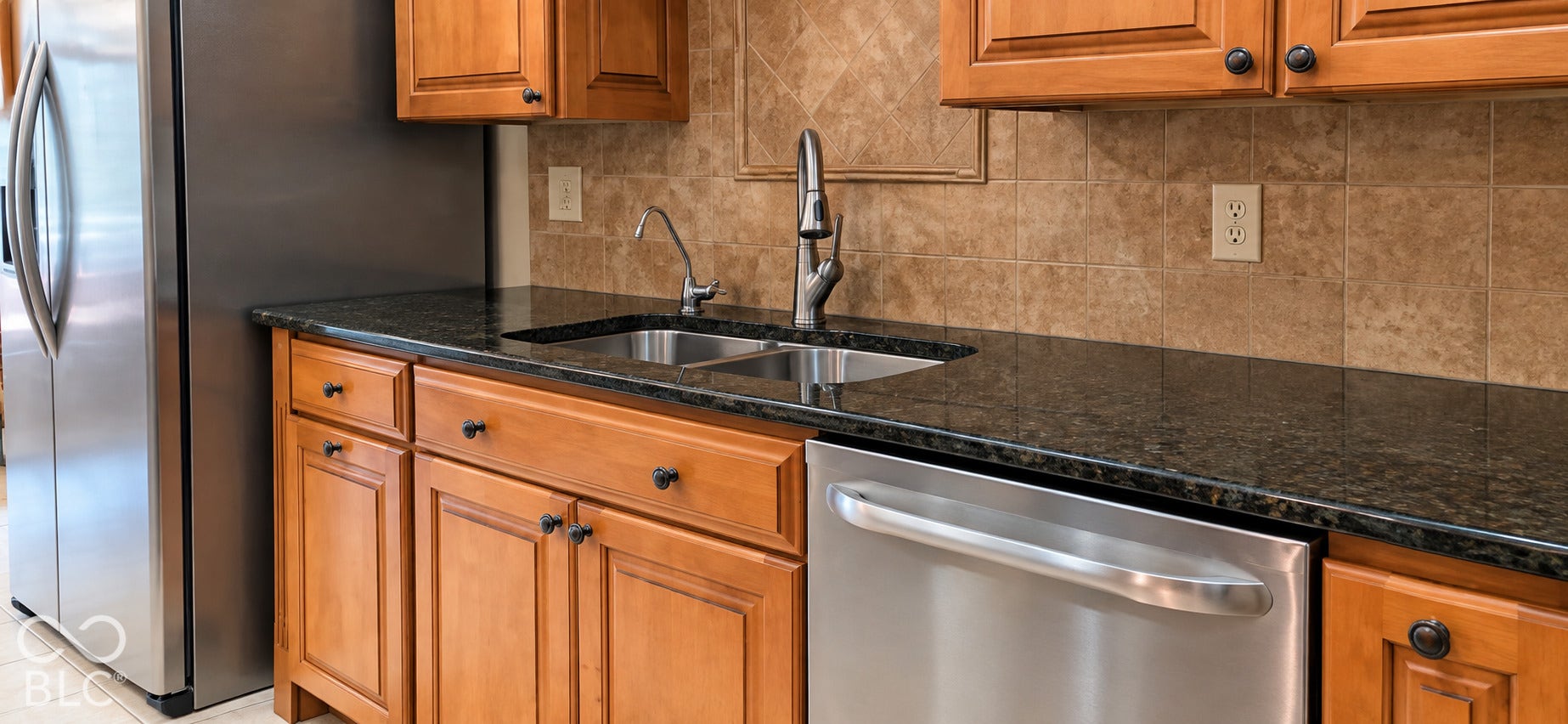 Kitchen featuring wood cabinetry, dark granite countertops, stainless steel appliances, and a tile backsplash