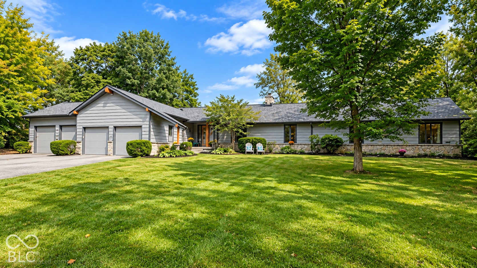 Ranch-style residence featuring a multi-car garage, stone and cedar siding exterior, and a prominent front entryway