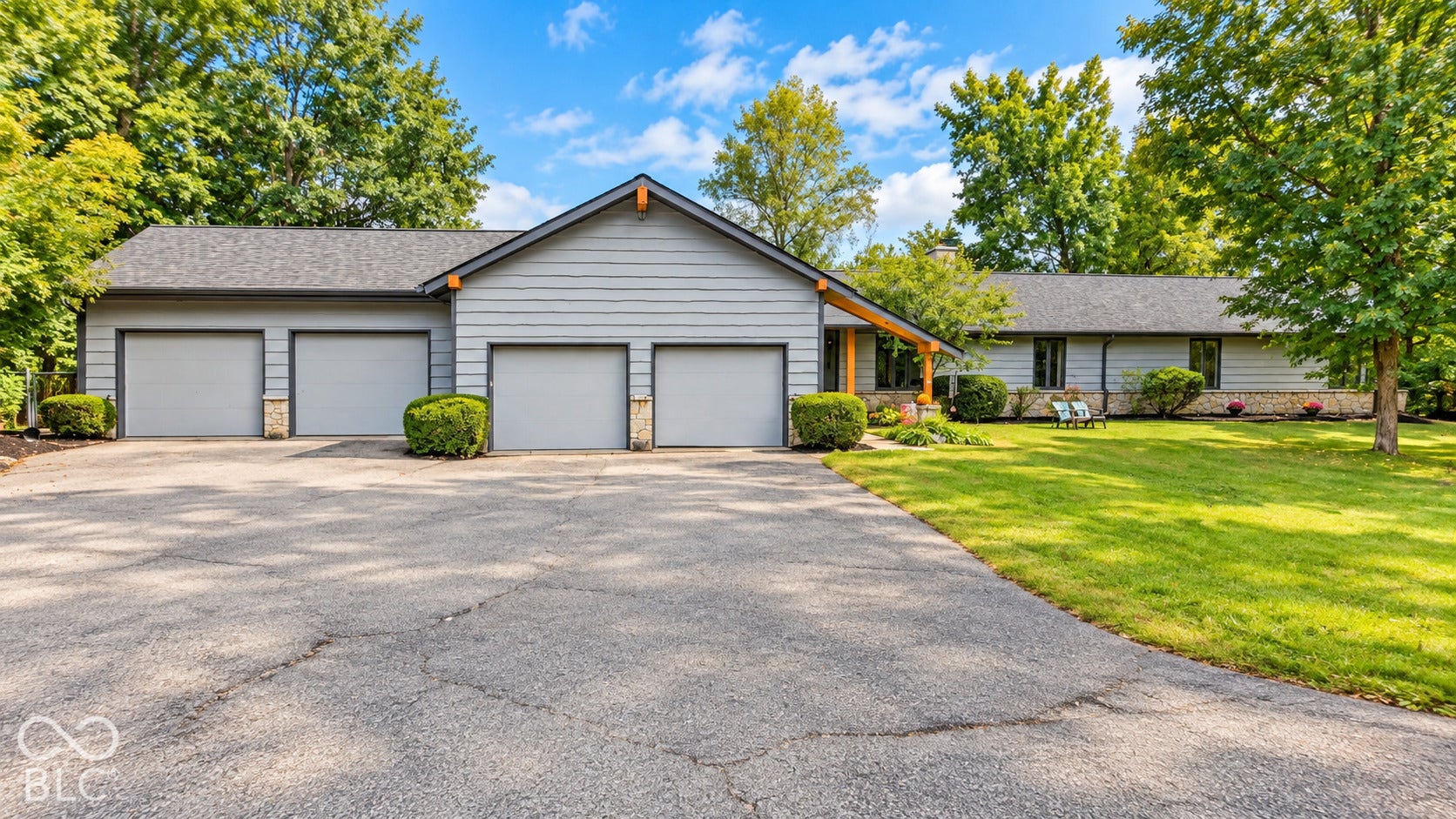 Expansive driveway leading to a four-car garage with light gray doors