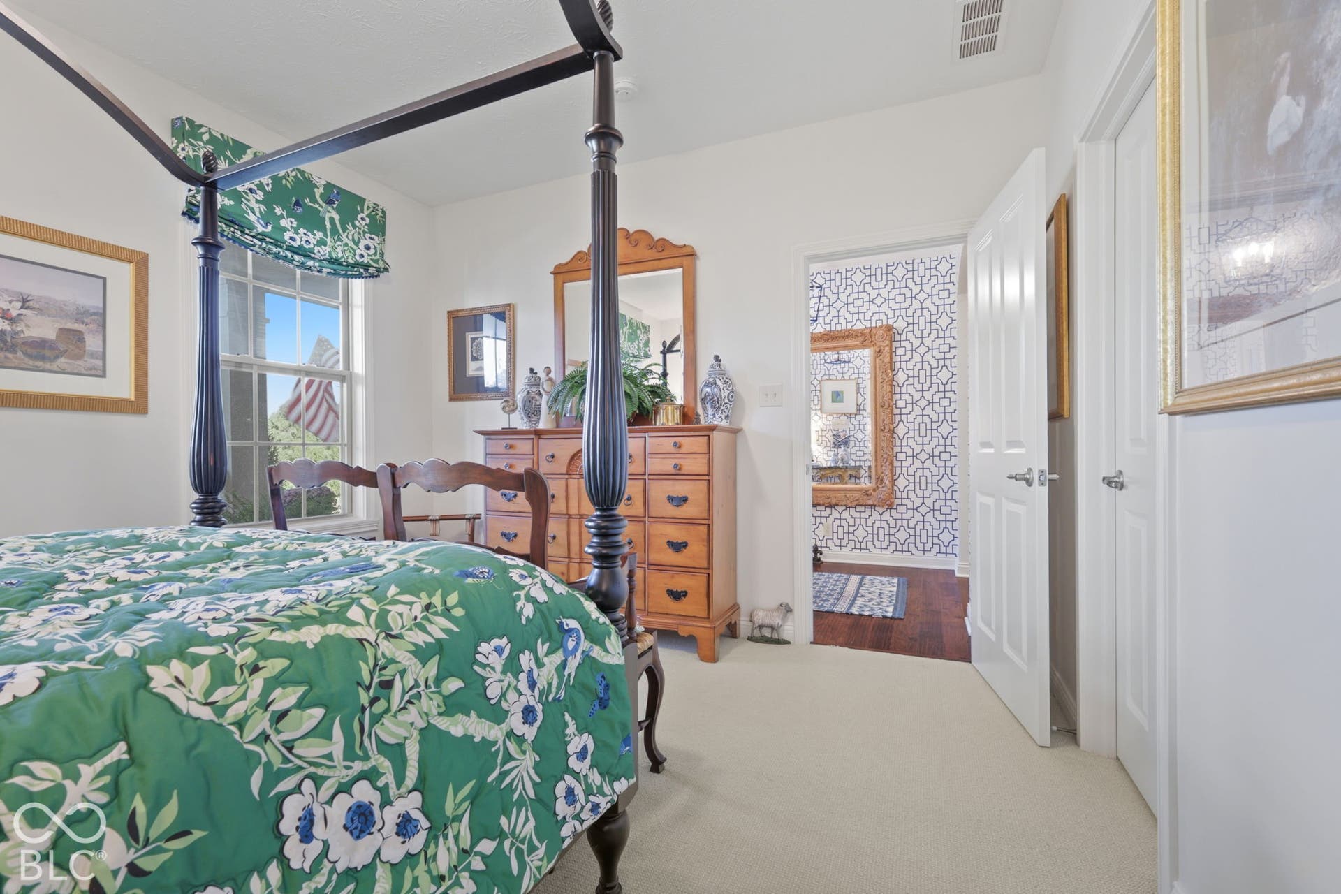 Carpeted flooring, white walls, and a window with a green valance