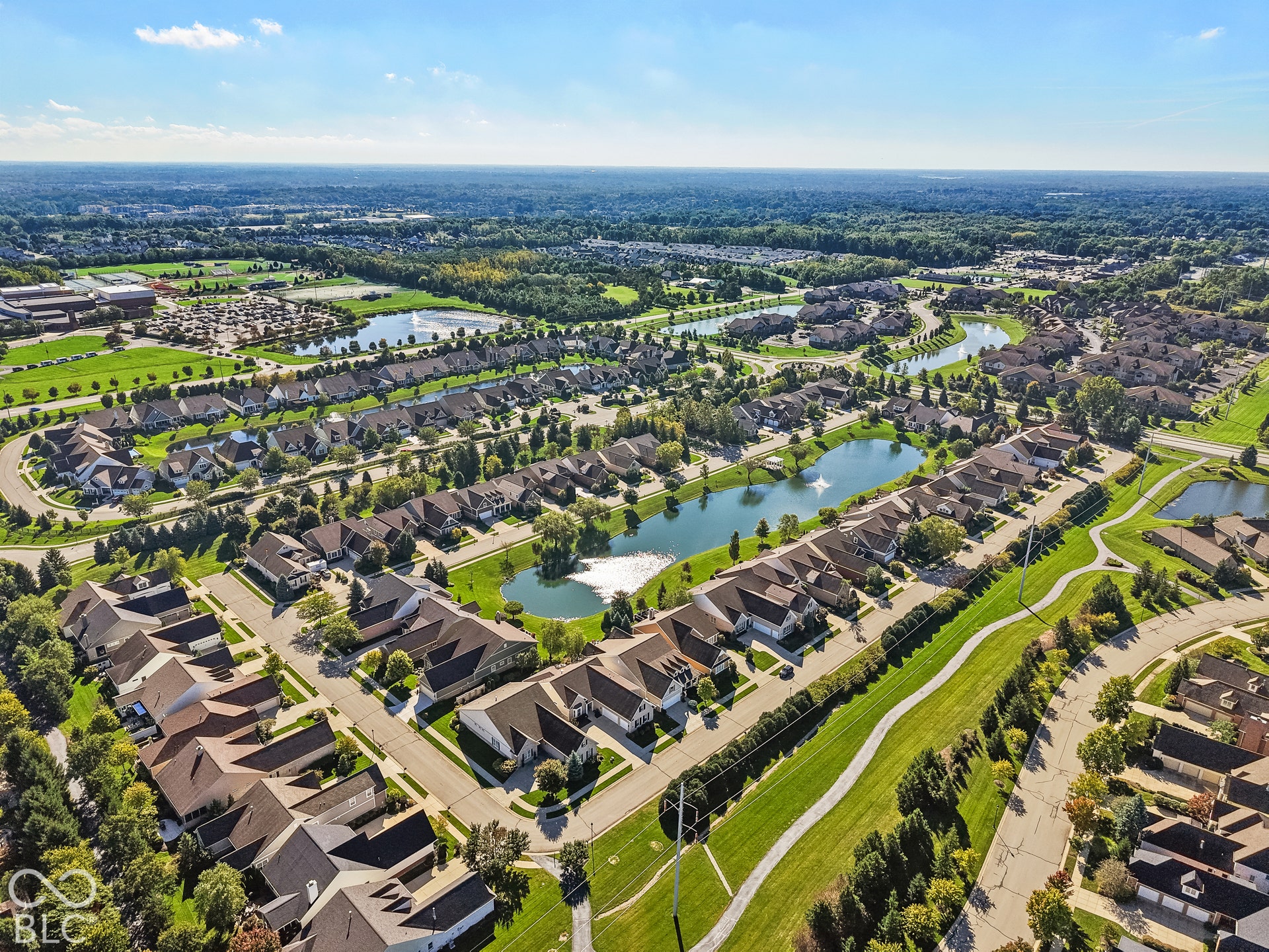 Virtually Altered - Aerial perspective of a developed residential community with multiple single-family homes, meandering waterways, and extensive green spaces