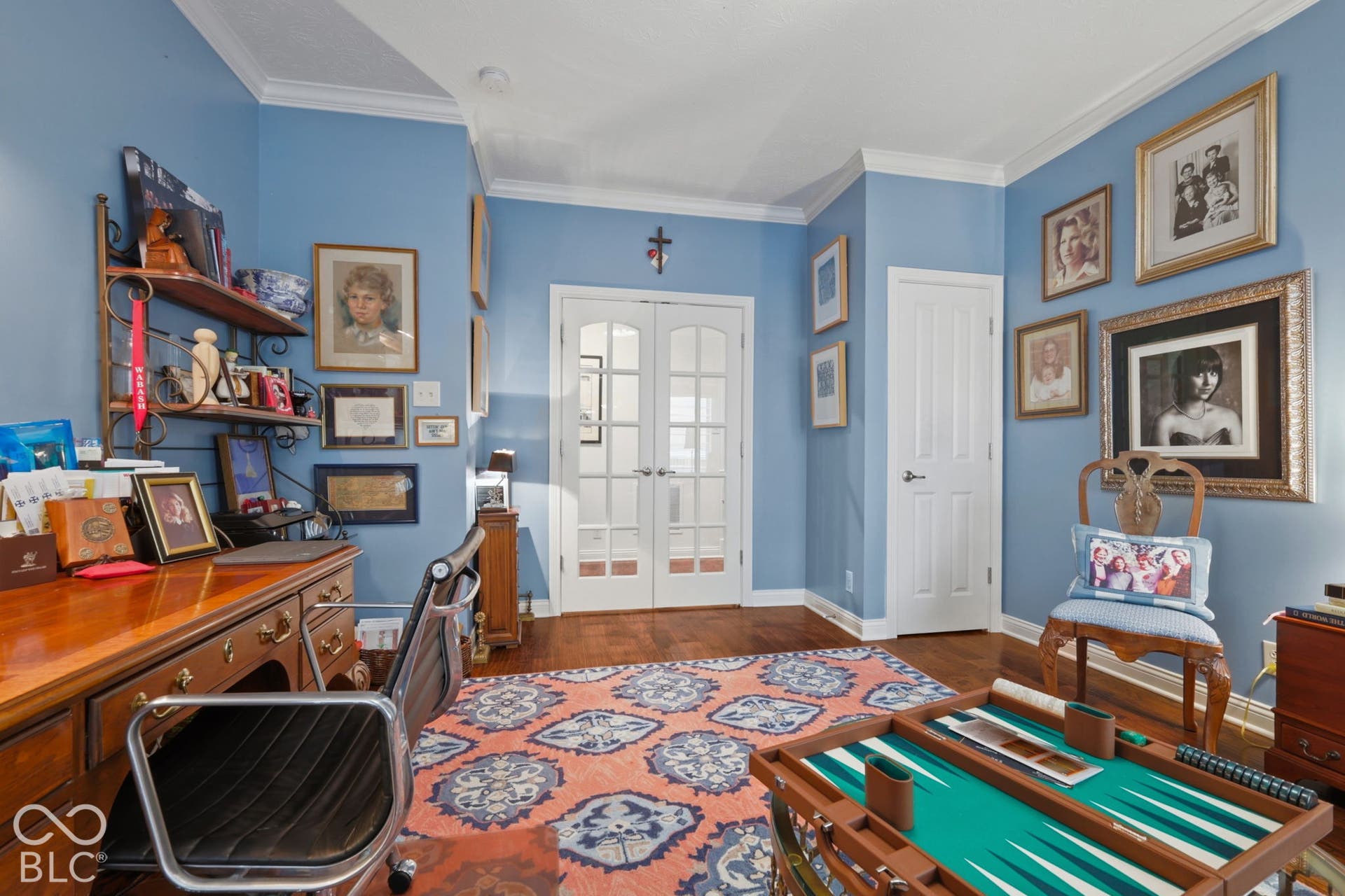 Hardwood flooring, crown molding, double French doors with glass panes, and a paneled door