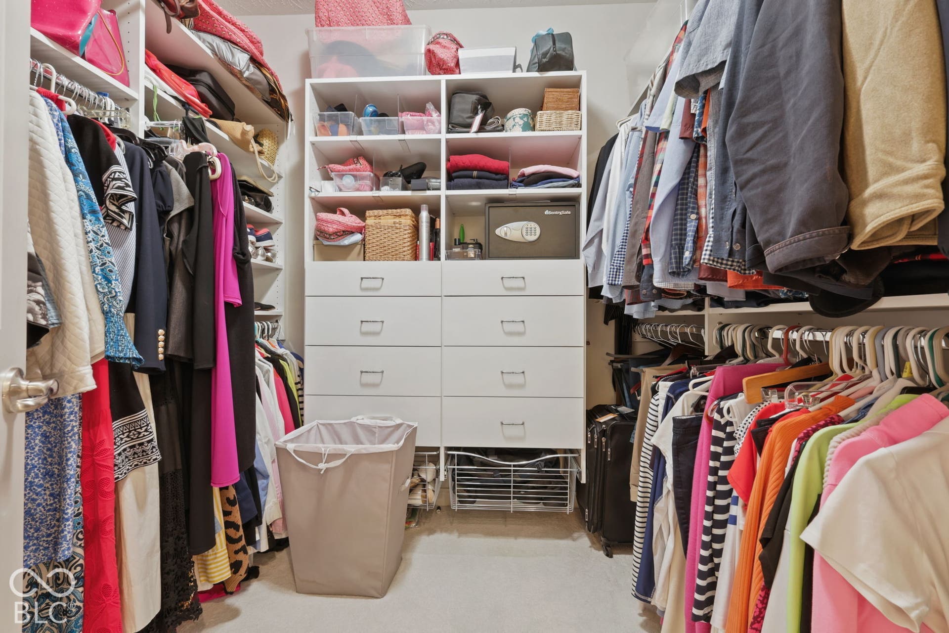 Built-in closet organization system featuring shelving, multiple hanging rods, and integrated drawers