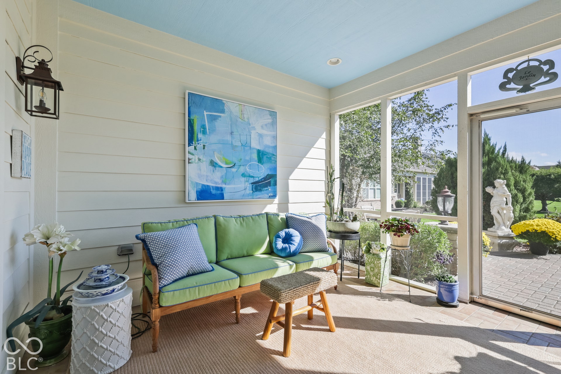 Virtually Altered - Screened porch featuring light blue ceiling, white shiplap walls, recessed lighting, and a paved patio