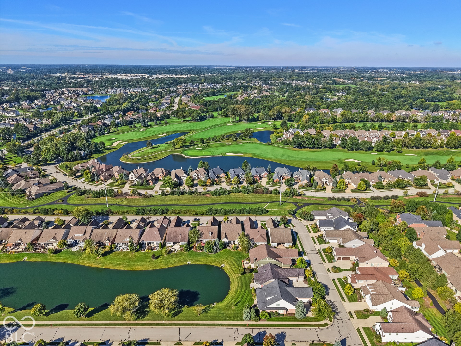 Virtually Altered - Aerial perspective showcasing a residential community with abundant green spaces, multiple water features, and expansive golf course frontage
