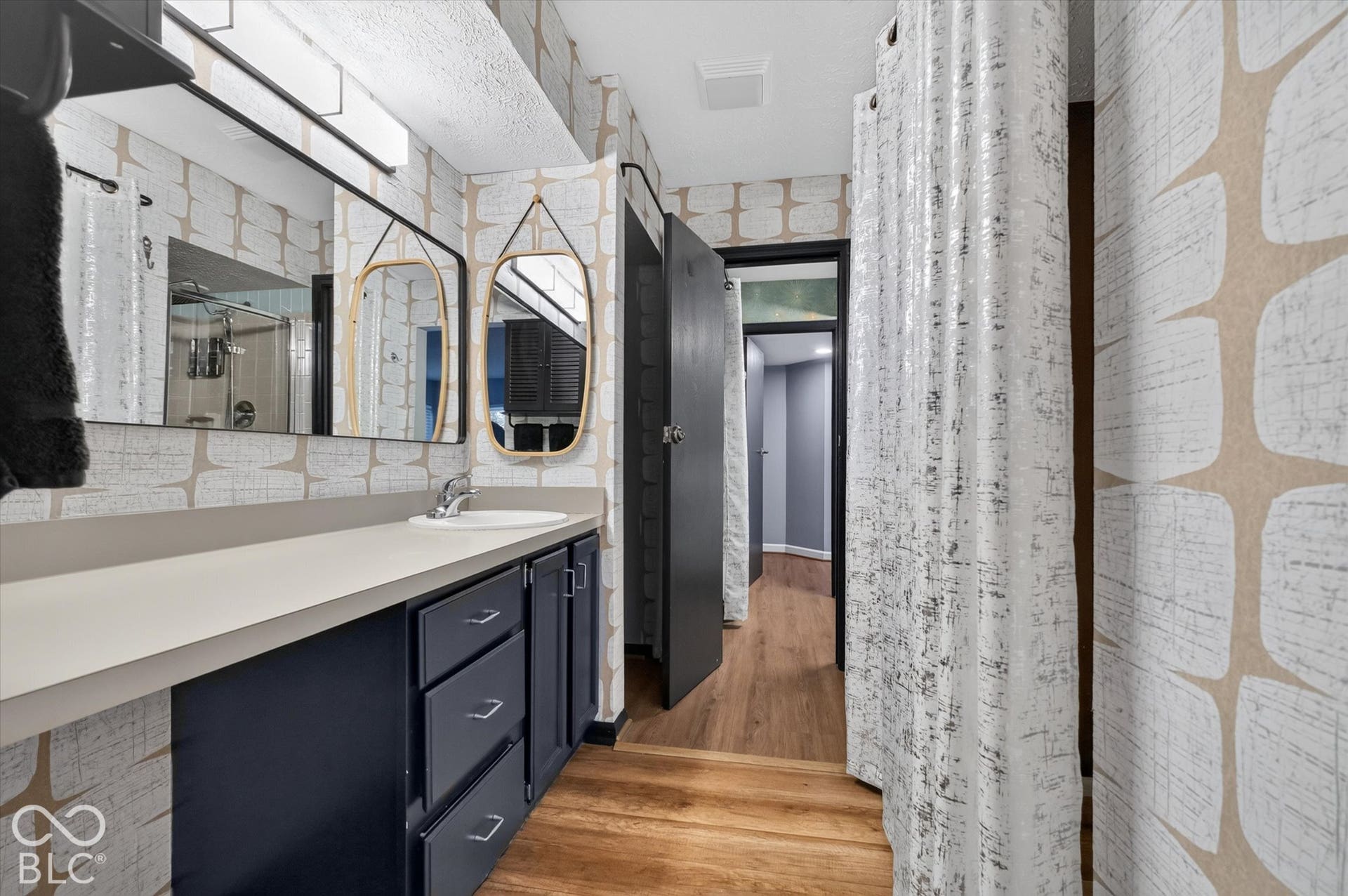 Vanity with single basin sink, matte countertop, and dark cabinetry