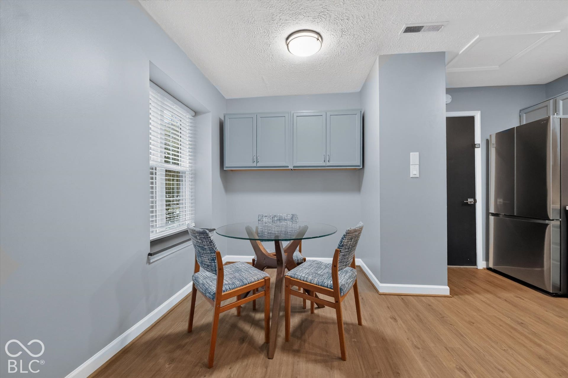 Wood-finish flooring throughout, complemented by a window with blinds
