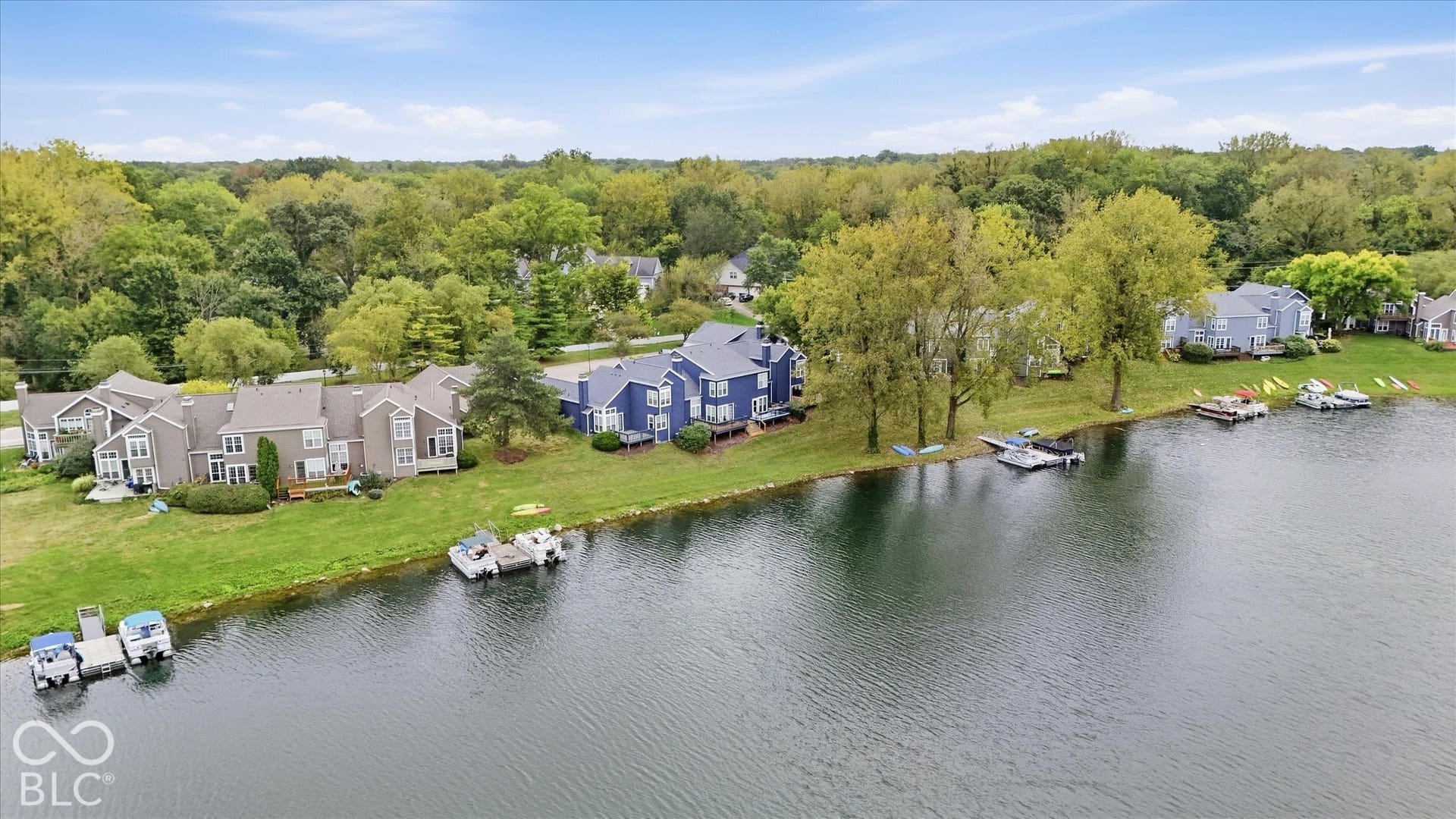 Waterfront property featuring a private boat dock, expansive grassy areas, and mature trees