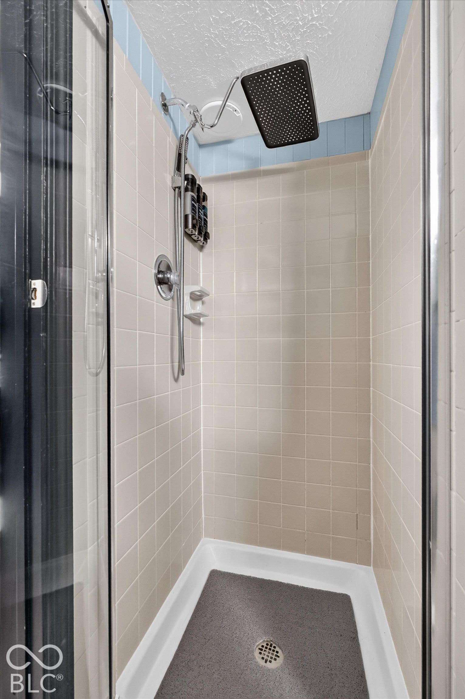 Tile-surround shower with a fixed rain shower head and a multi-function handheld shower