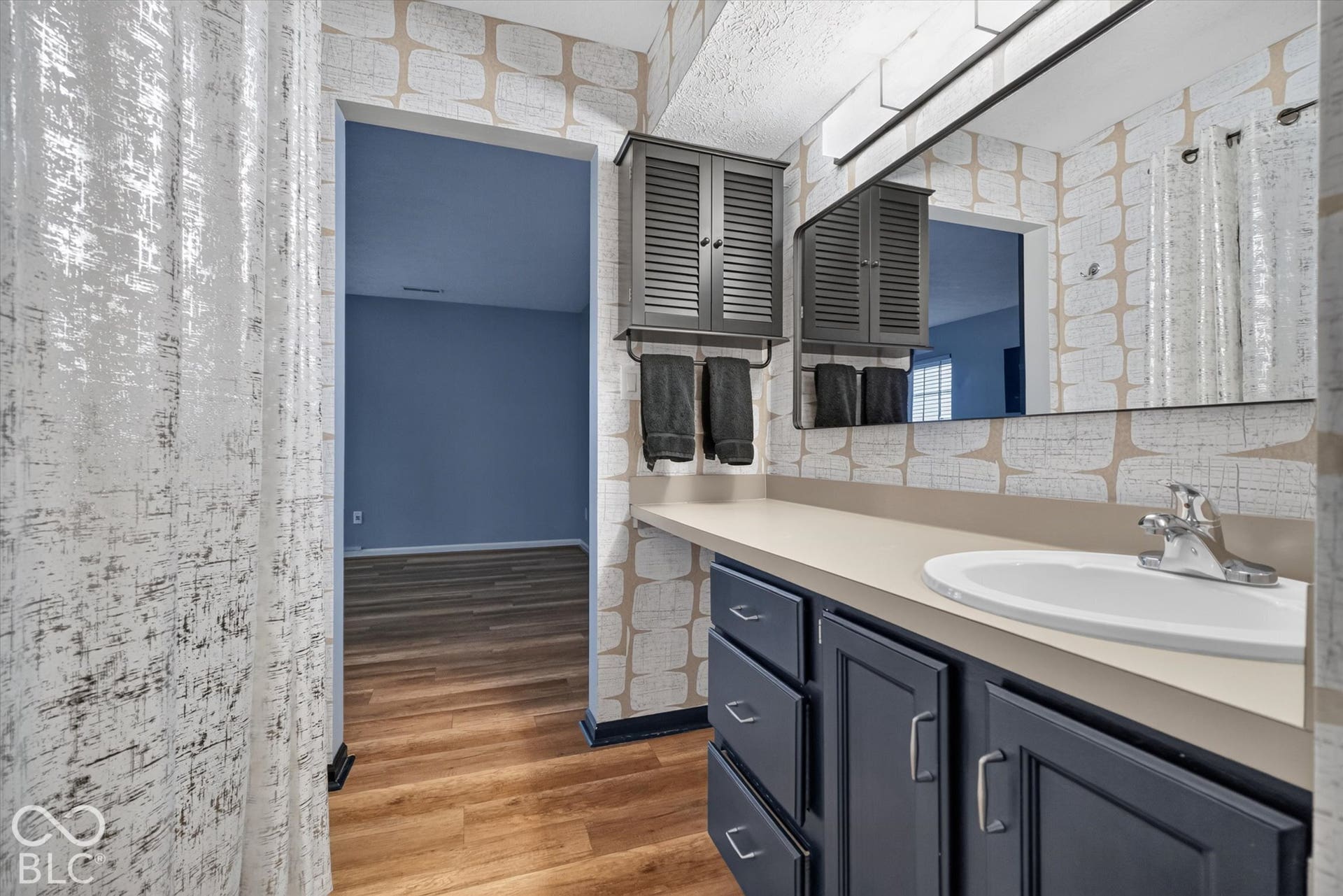 Vanity with integrated sink, chrome faucet, and dark wood-finish cabinetry