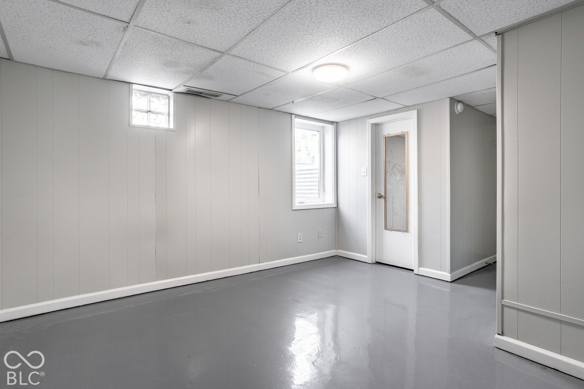 Basement bedroom - Recessed lighting, drop ceiling, paneling walls, epoxy flooring, glass block egress window