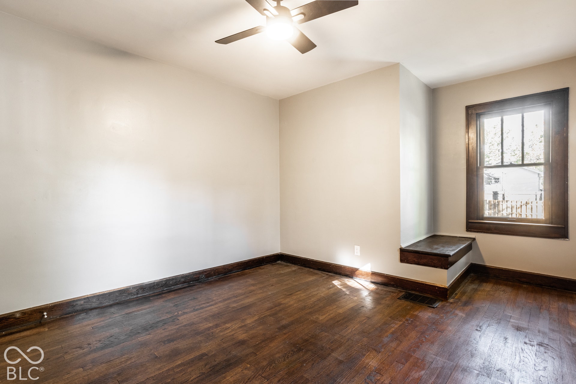 Bedroom 1 - Hardwood flooring, painted walls, ceiling fan, and natural light