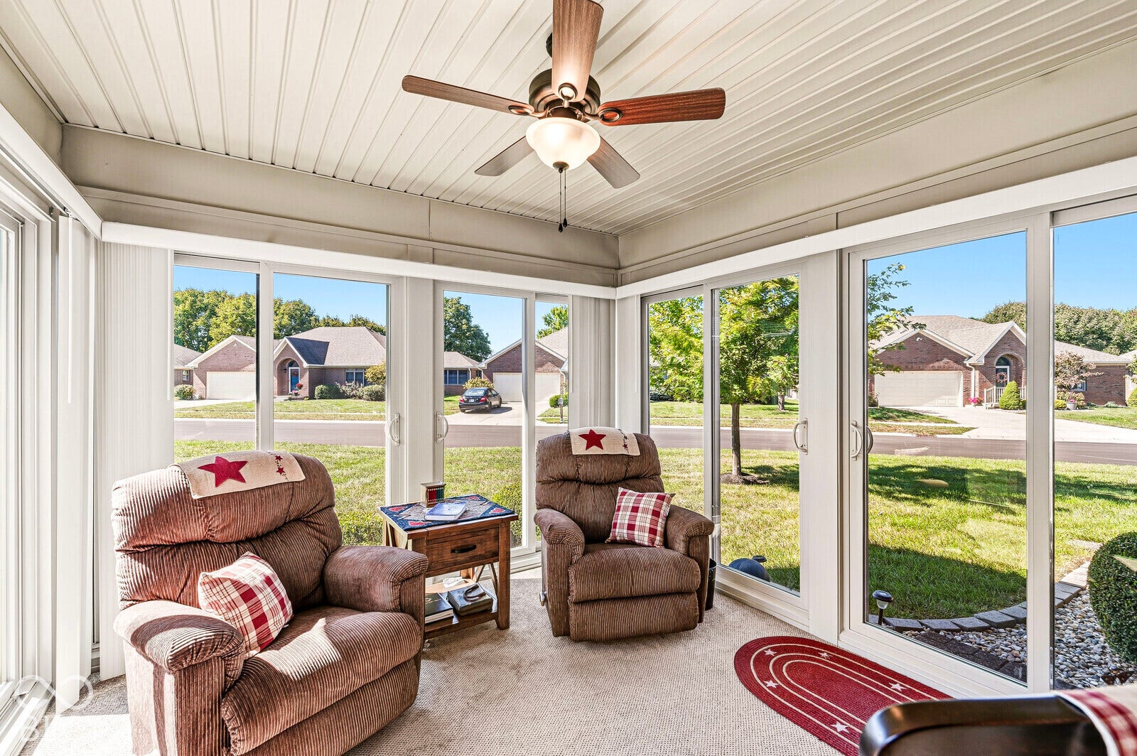 4-season sunroom - approximately 11 x 12, with a ceiling fan/light, sliding glass doors, and blinds. Separate HVAC unit