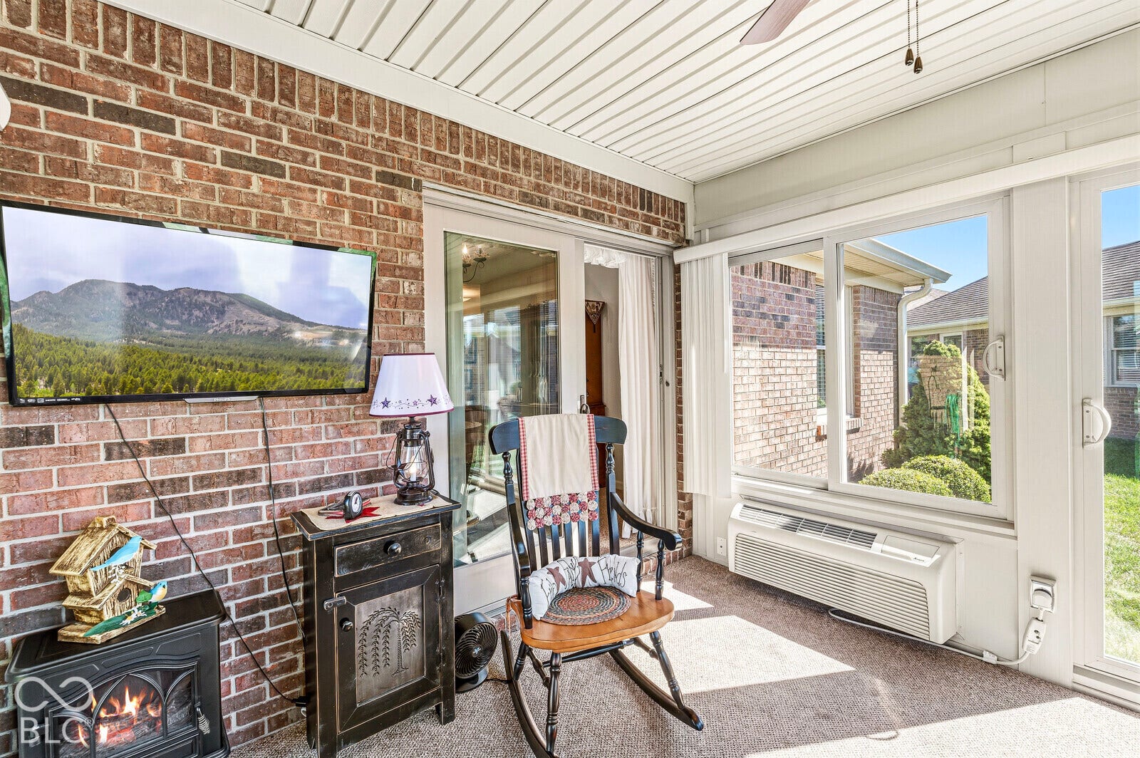 4-season sunroom with blinds for privacy. Separate HVAC unit and a ceiling fan.