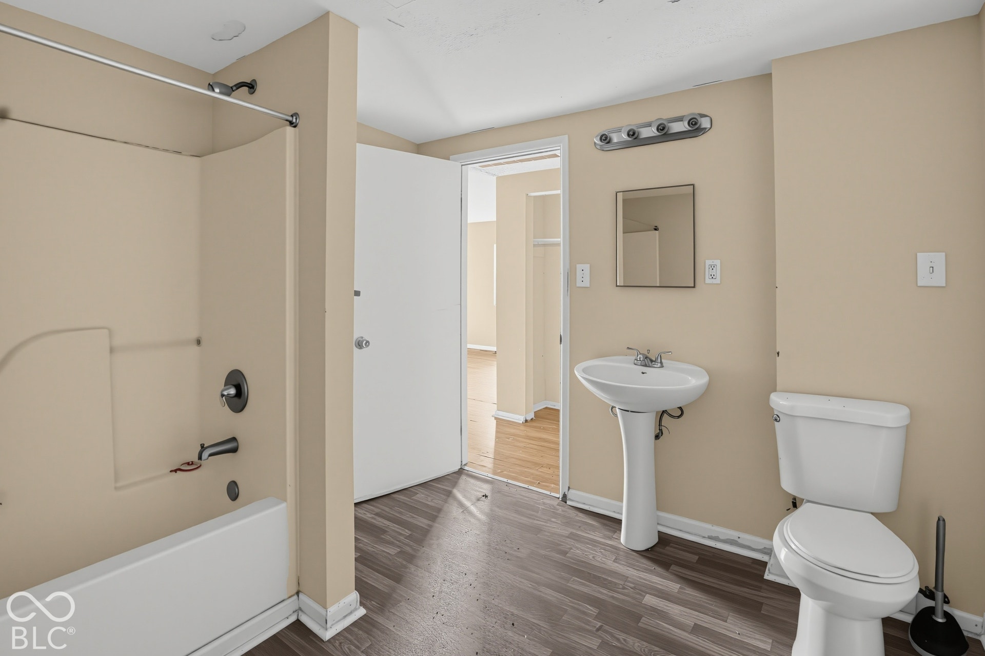 3128 S Rural Street, Indianapolis, IN 46237 Pedestal sink, wall-mounted mirror with overhead vanity lighting, and wood-finish flooring