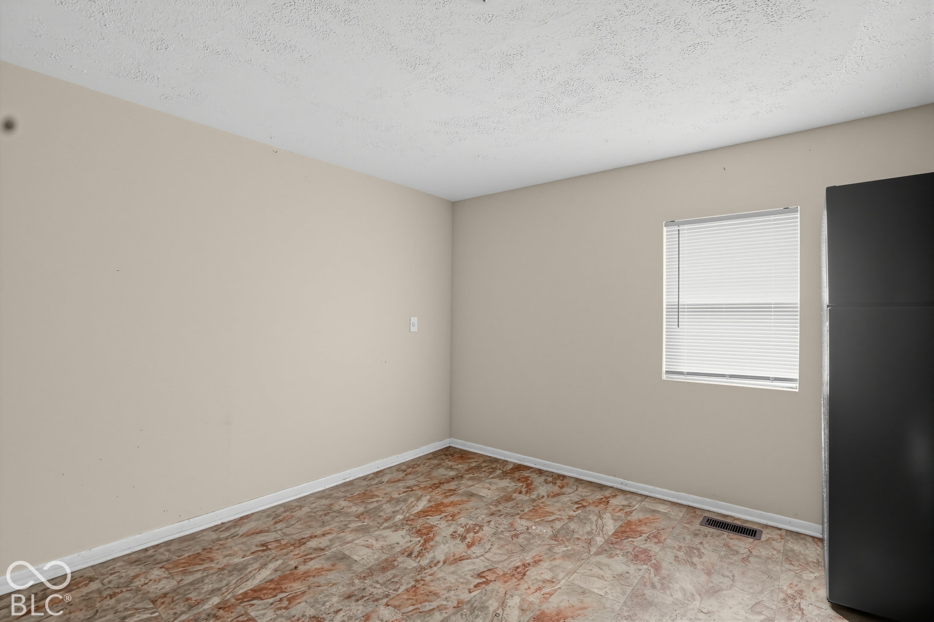 3128 S Rural Street, Indianapolis, IN 46237 Recessed window with white blinds, neutral wall paint, textured ceiling, and patterned floor tiles