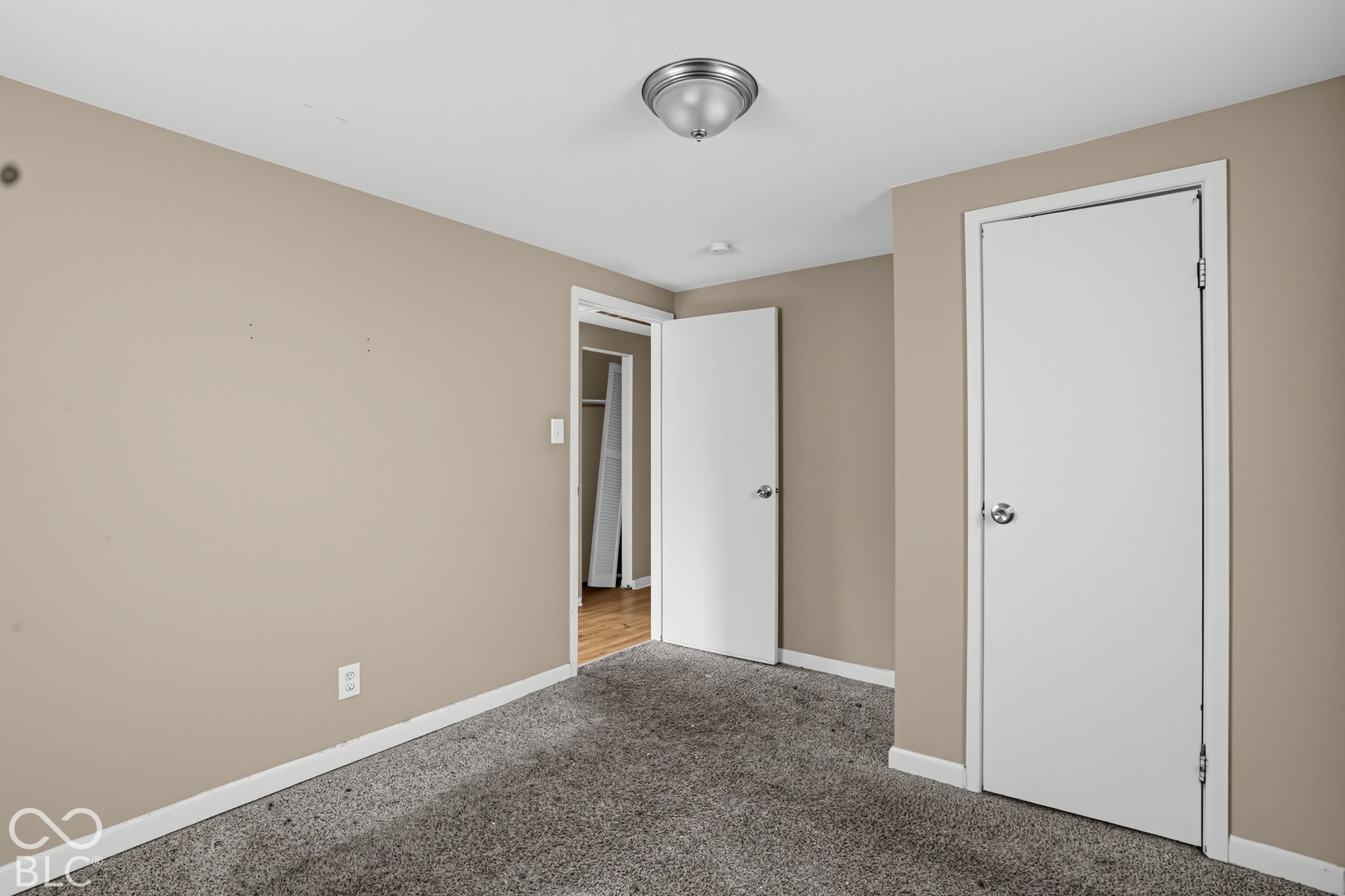 3128 S Rural Street, Indianapolis, IN 46237 Neutral-toned wall finish, gray carpet flooring, flush-mount ceiling light fixture, and white interior doors