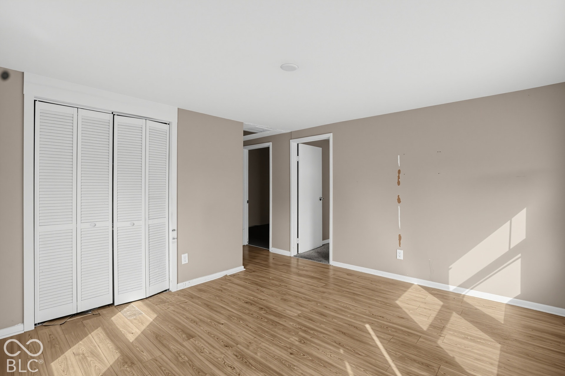 3128 S Rural Street, Indianapolis, IN 46237 Light wood-finish flooring, neutral wall paint, white trim, recessed lighting, and white louvered bifold closet doors