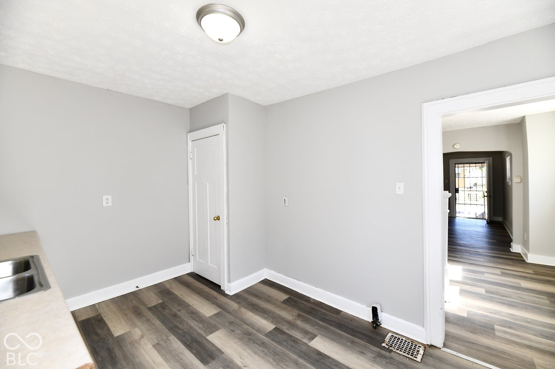 Wood-finish flooring, light gray wall paint, and white trim throughout