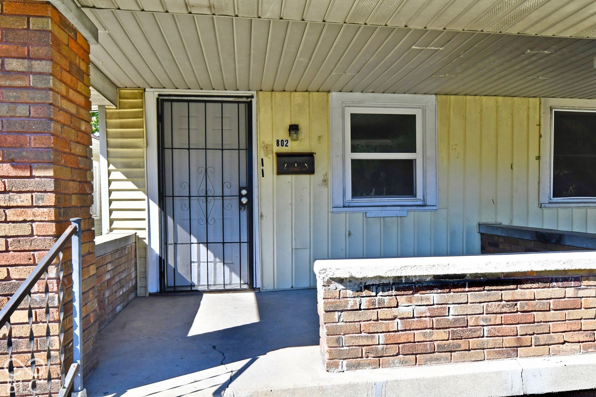 Brick column and low wall with a metal railing
