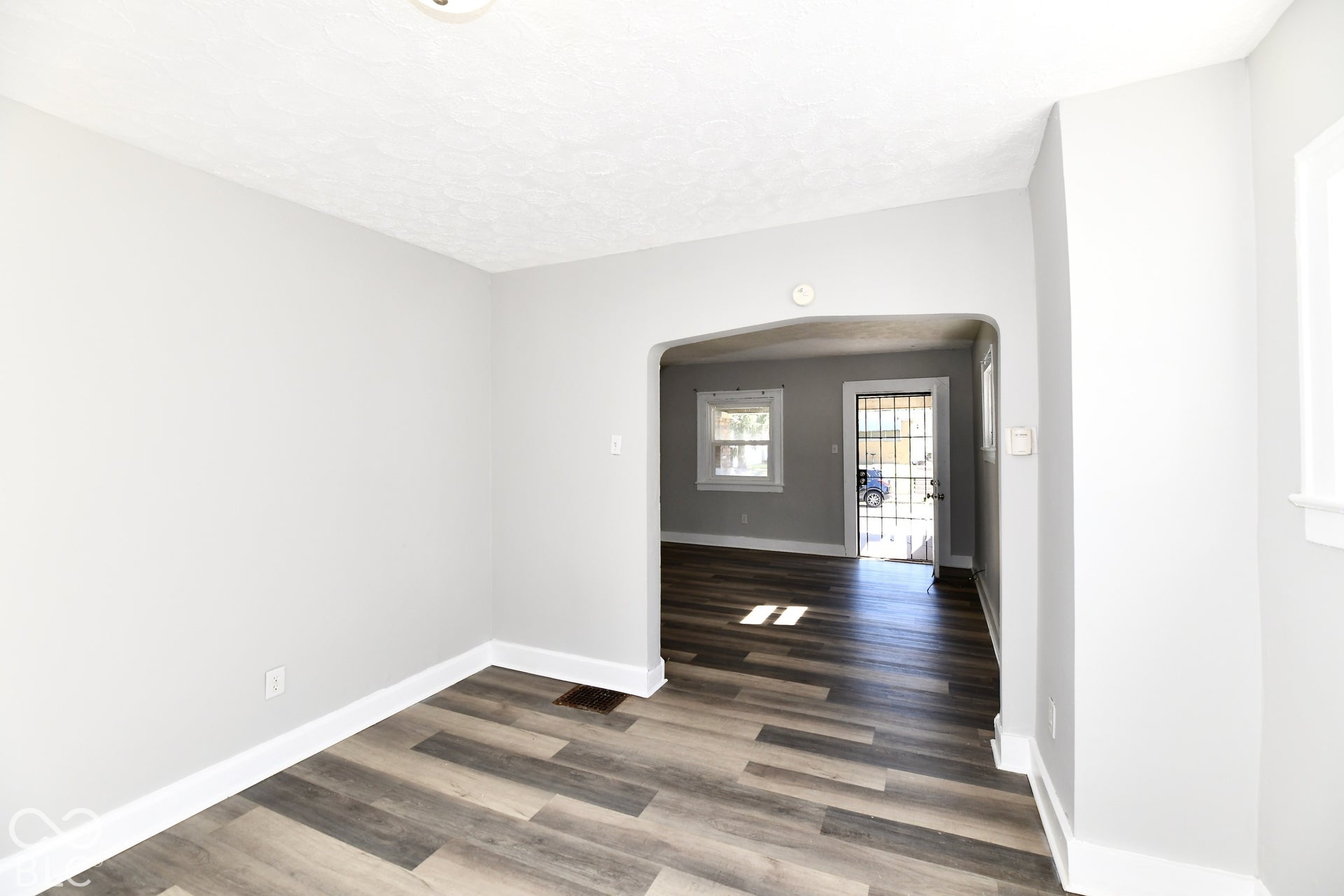 Archway opening into a room with wood-finish flooring