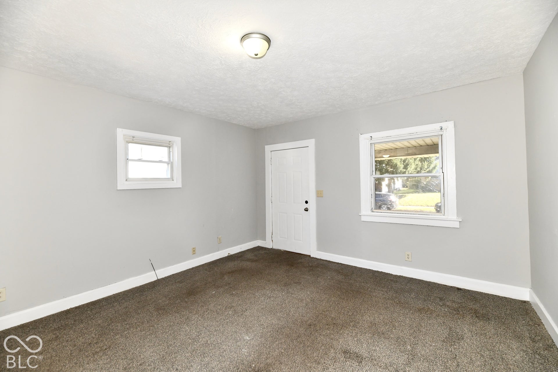 Recessed lighting, light gray wall paint, white trim, and two windows