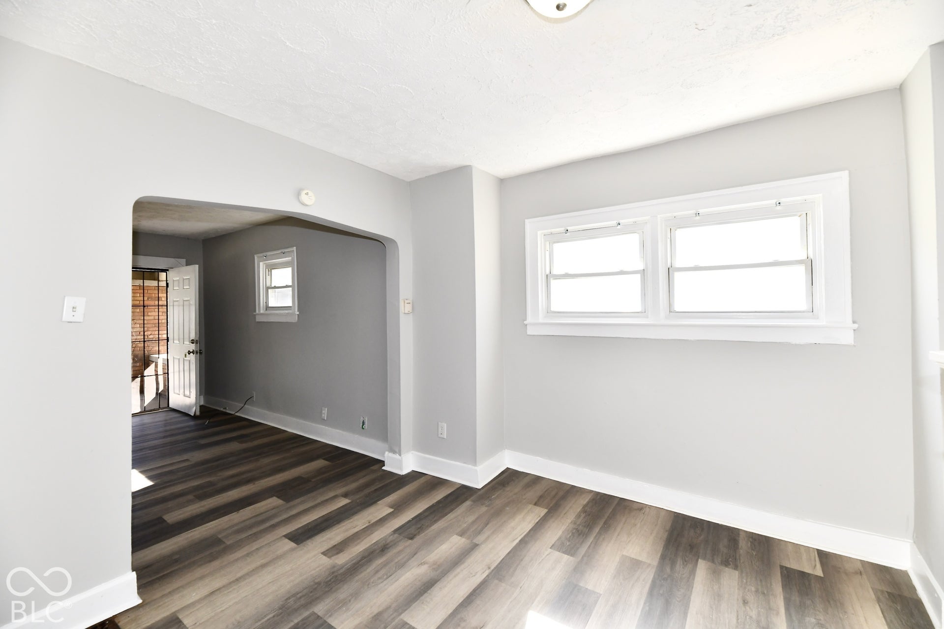 Wood-finish flooring, white trim, and light gray walls