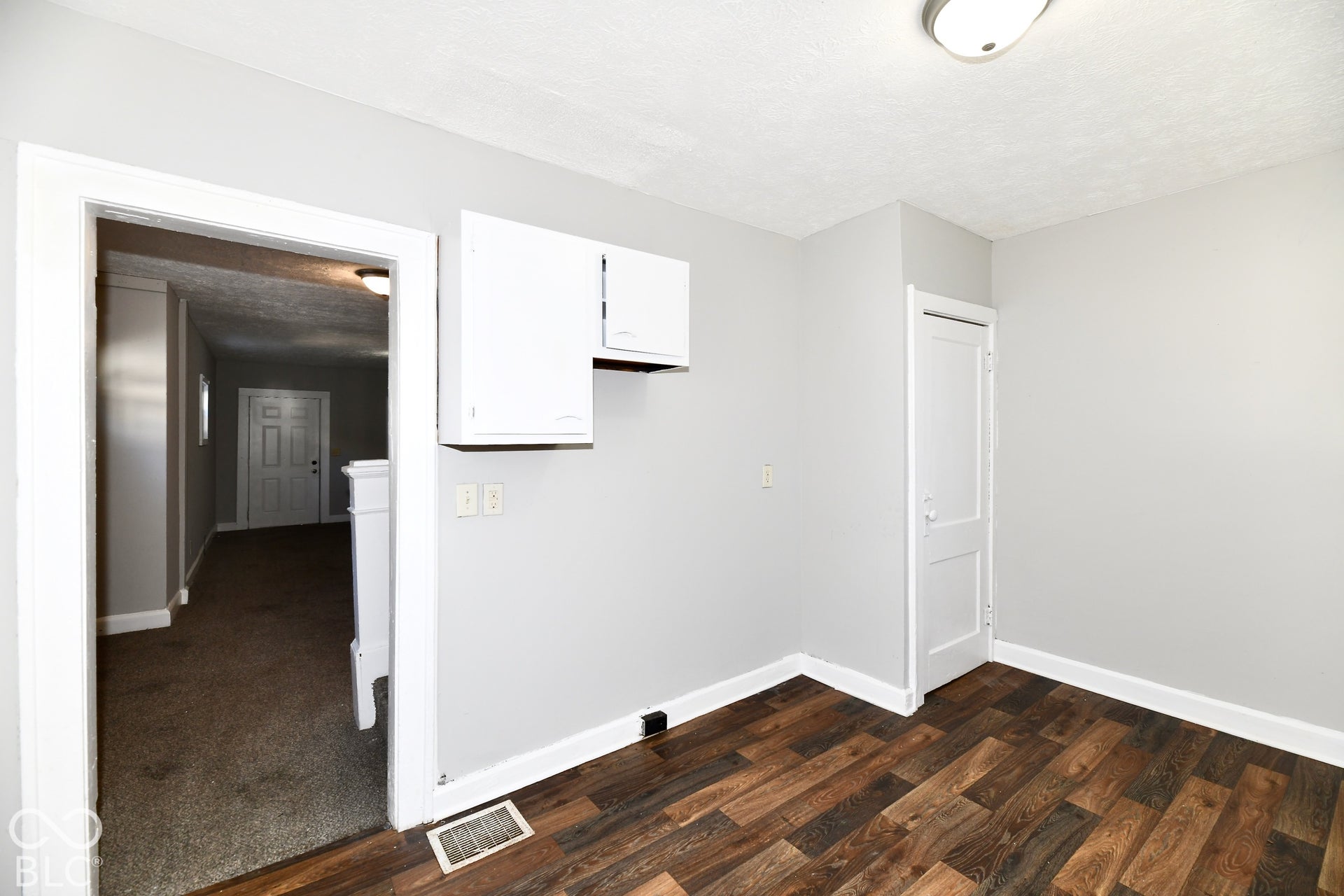 Wood-finish flooring with light gray walls and white trim