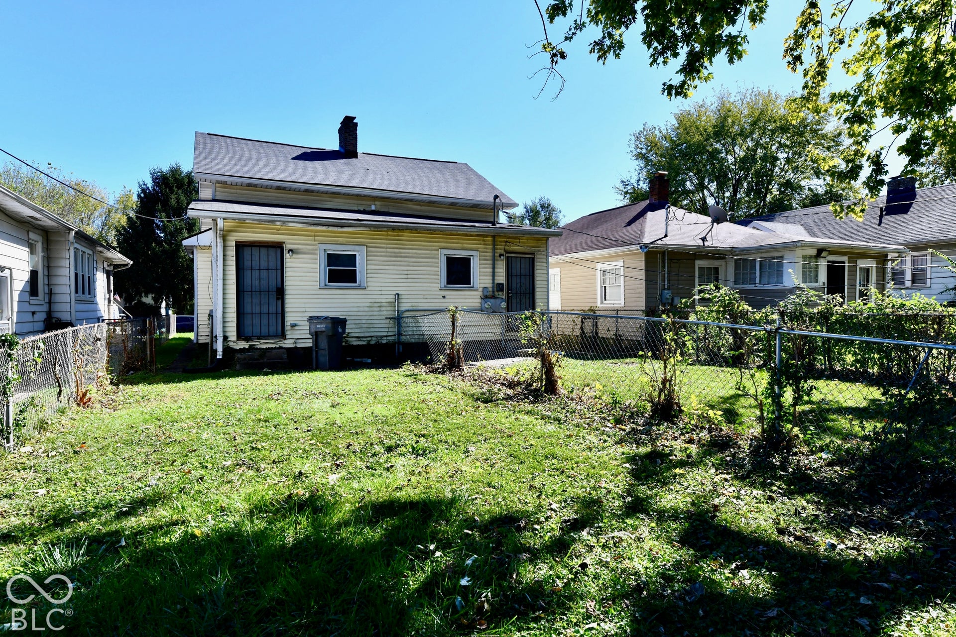 Expansive grassy yard with mature foliage