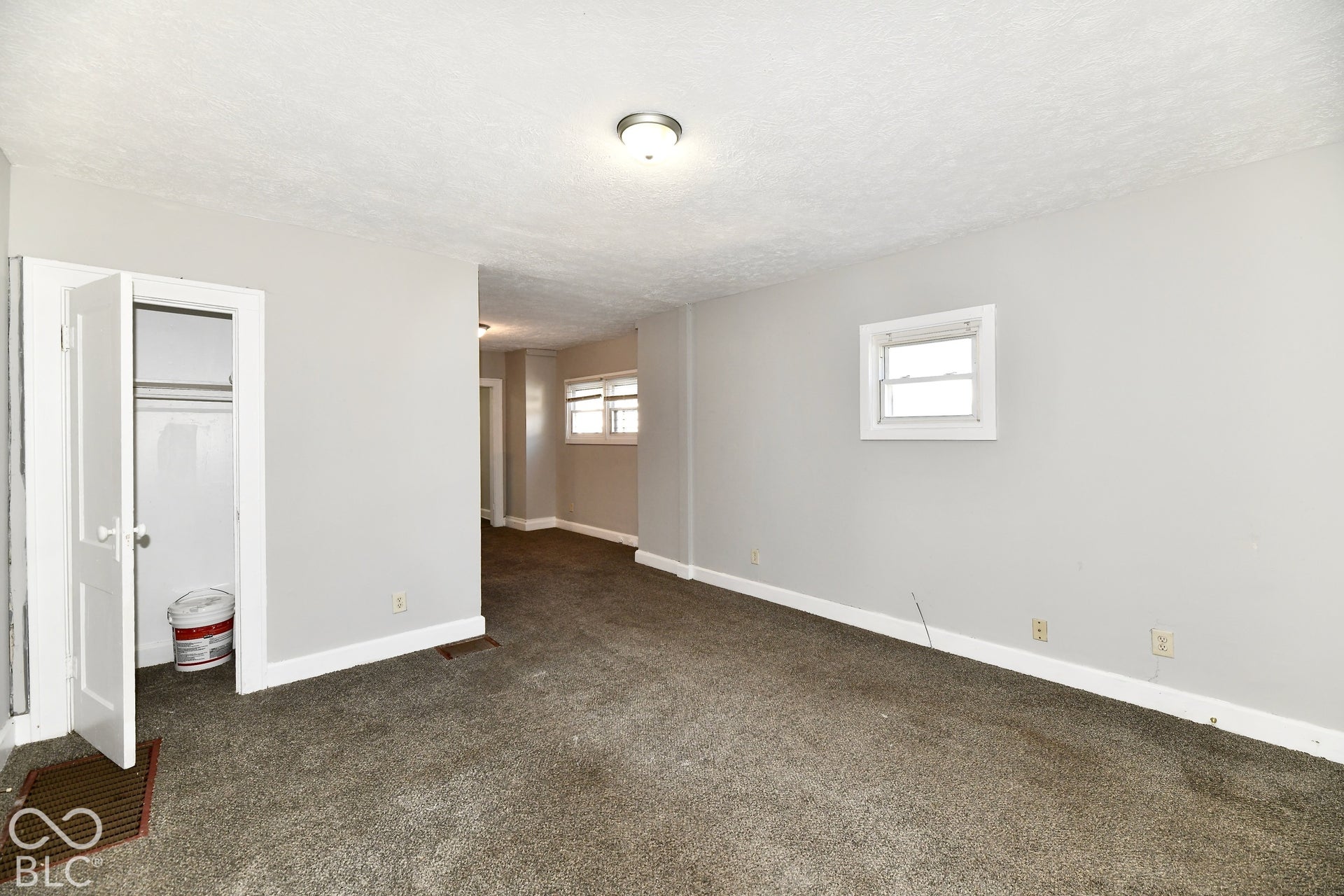Neutral gray wall paint with white trim, built-in closet with white door, and textured ceiling