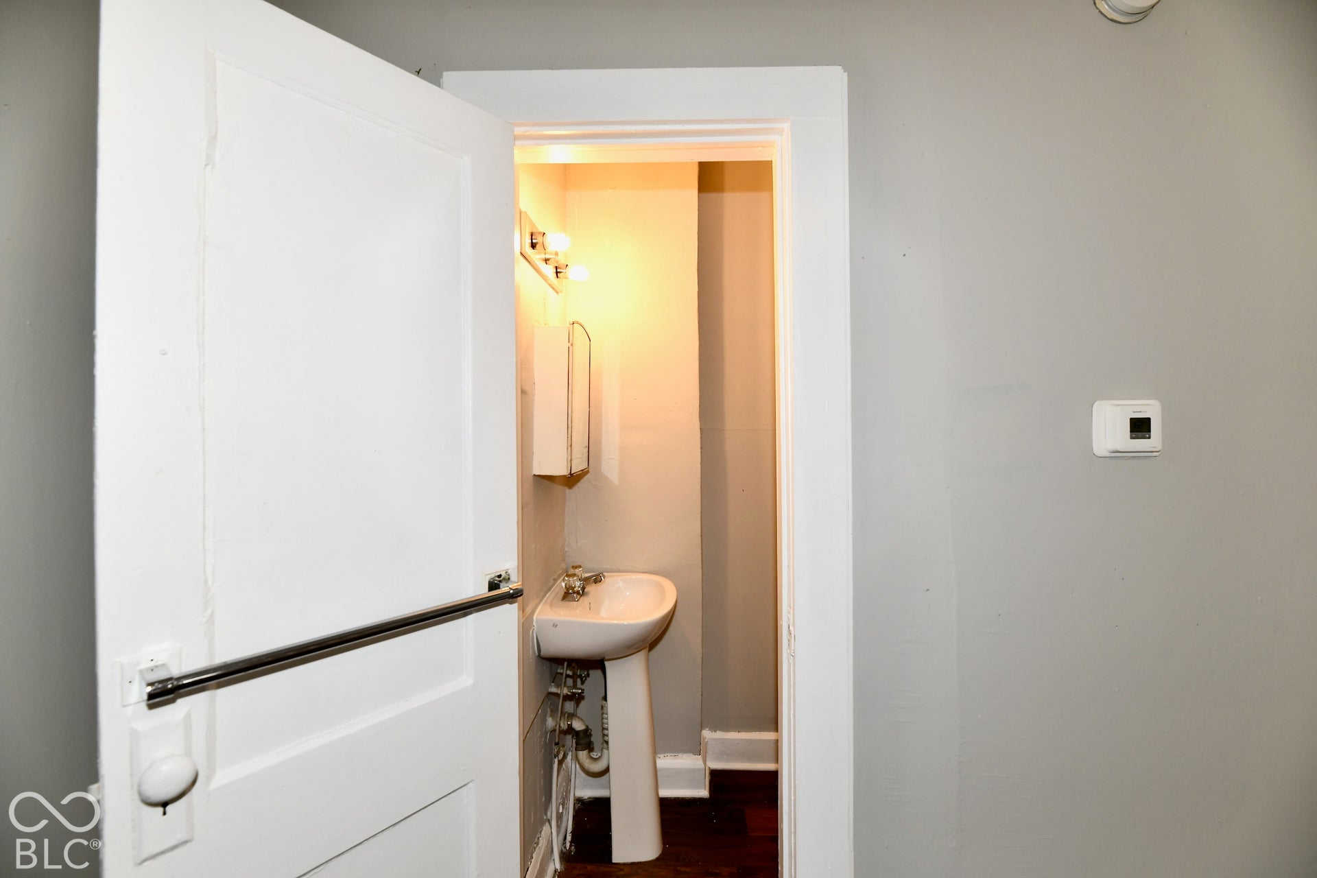 Pedestal sink with wall-mounted medicine cabinet and vanity lighting