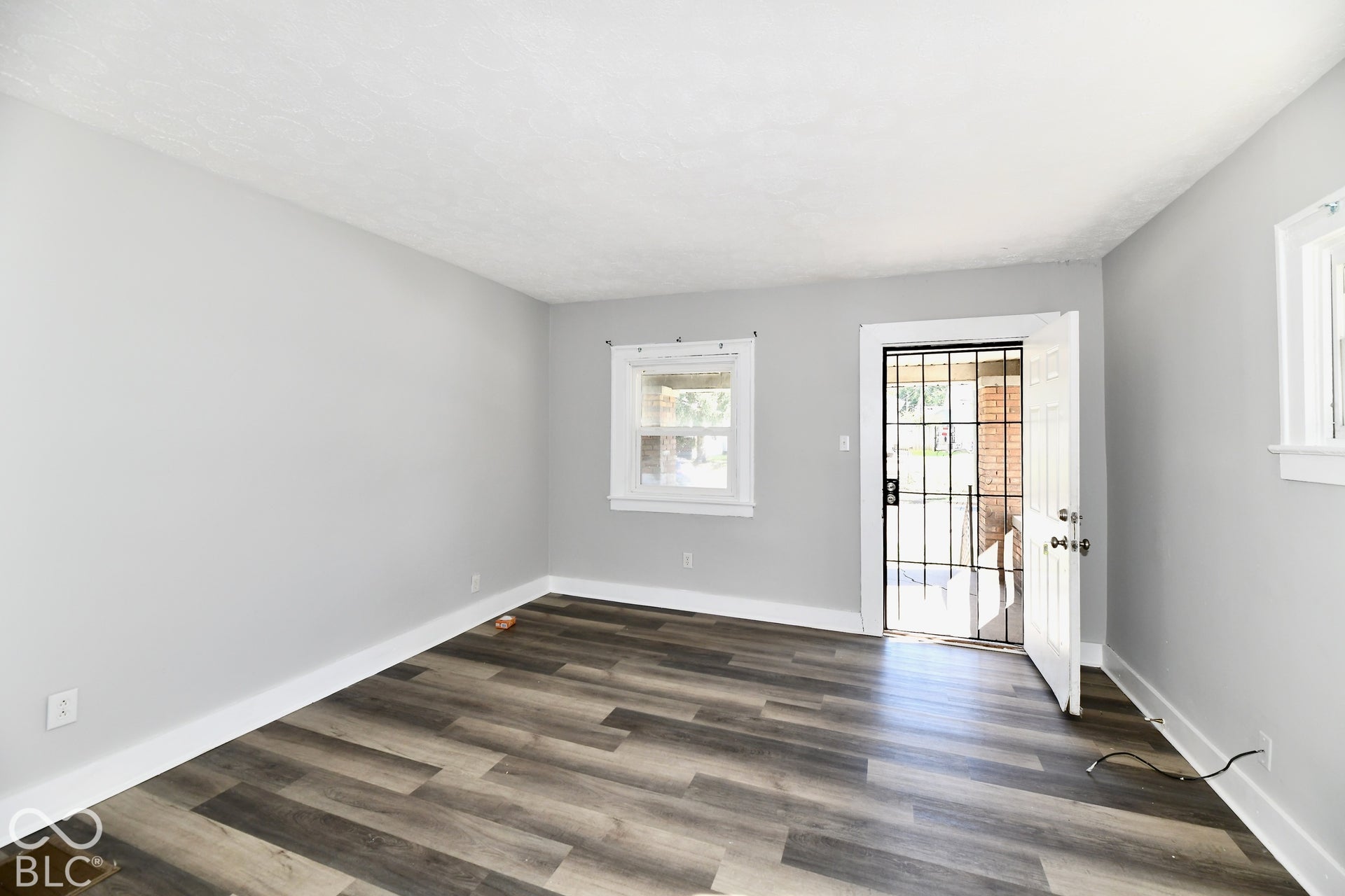 Hard-surface wood-finish flooring, white trim, light gray painted walls, and white ceiling