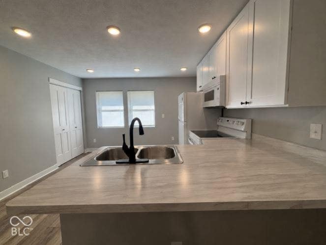 252 Indiana Street, Plainfield, IN 46168 Kitchen featuring white cabinetry, a double basin stainless steel sink with a matte black faucet, light-toned countertops, and recessed lighting